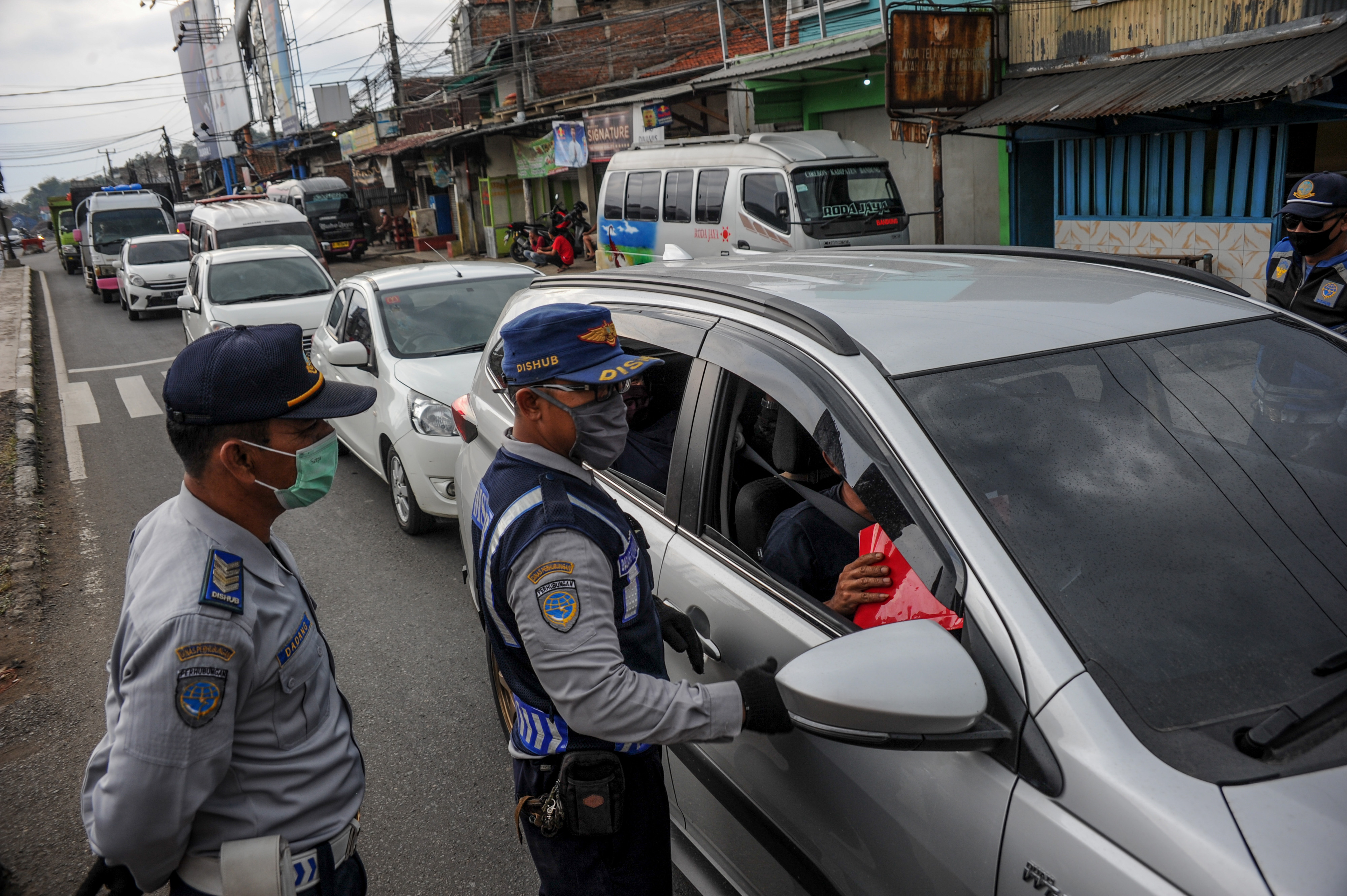  Petugas gabungan memeriksa kendaraan  di titik pemeriksaan penyekatan pemudik di Cileunyi, Kabupaten Bandung, Minggu (17/5/2020).