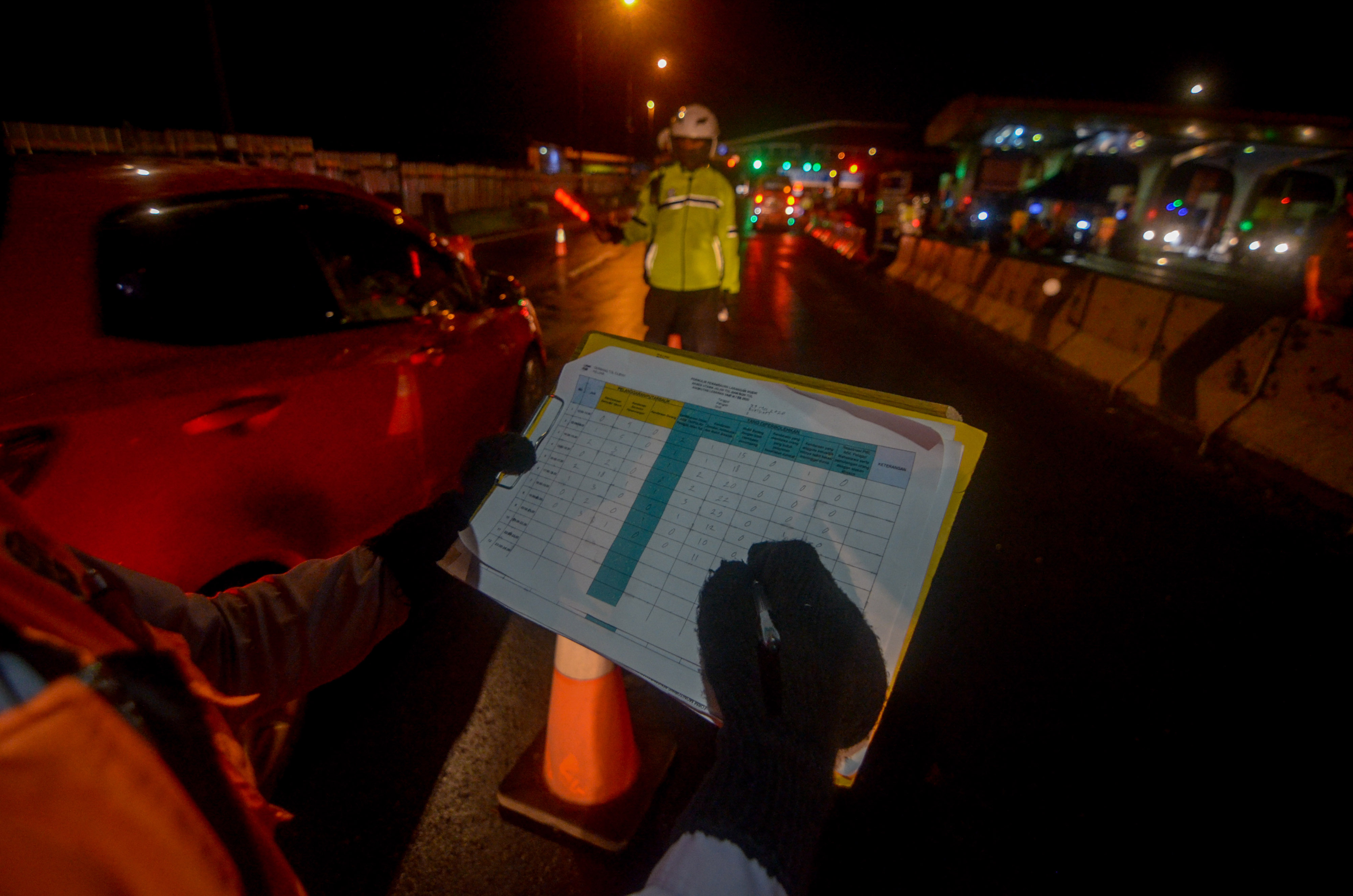 Petugas mencatat arus kendaraan saat penyekatan arus balik menuju Jakarta di Gerbang Tol Cileunyi, Bandung, Jawa Barat, Rabu (27/5).