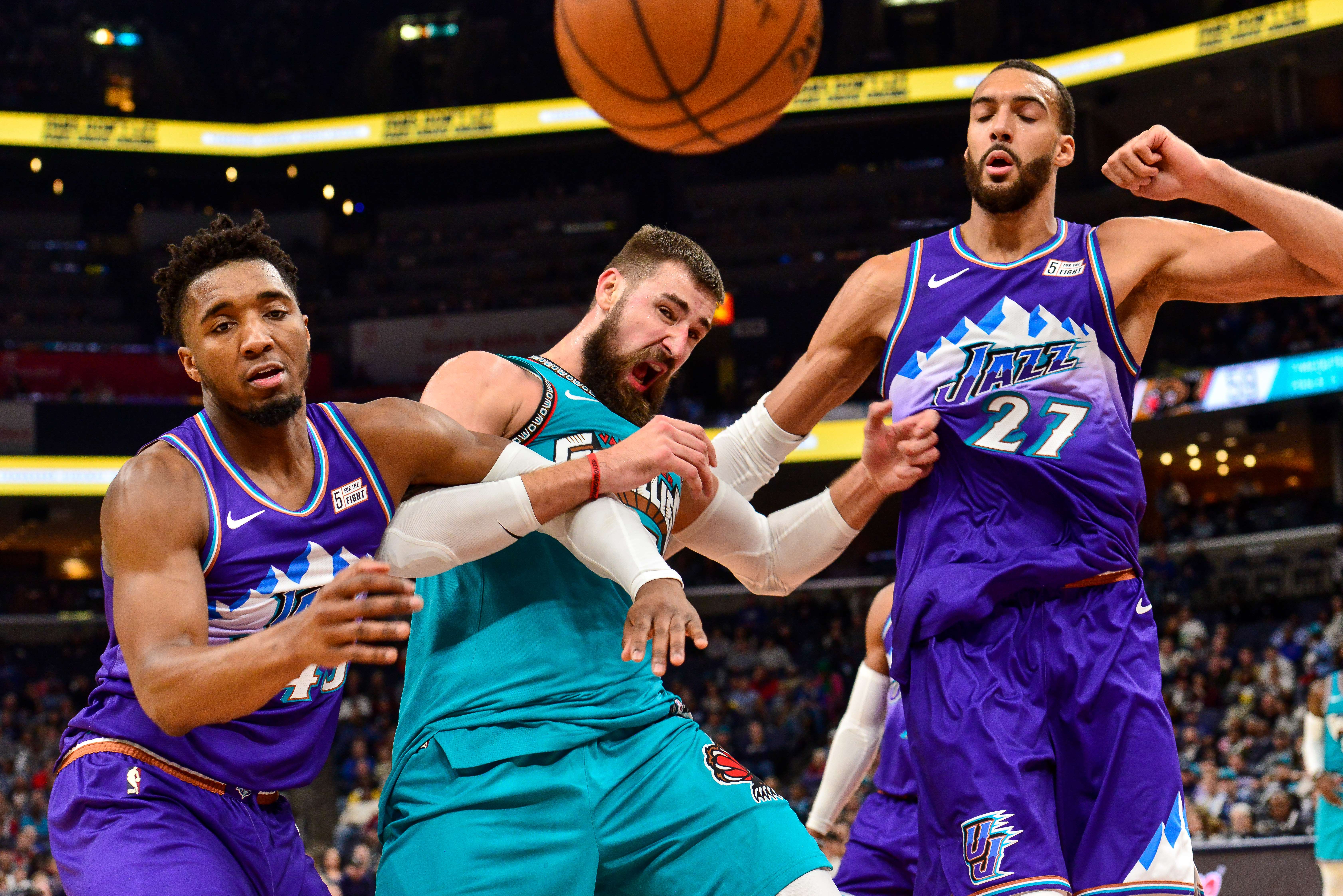 Duet Utah Jazz Donovan Mitchell (kiri) dan Rudi Gobert (kanan) mengapit pemain Memphis Grizzlies Jonas Valanciunas.