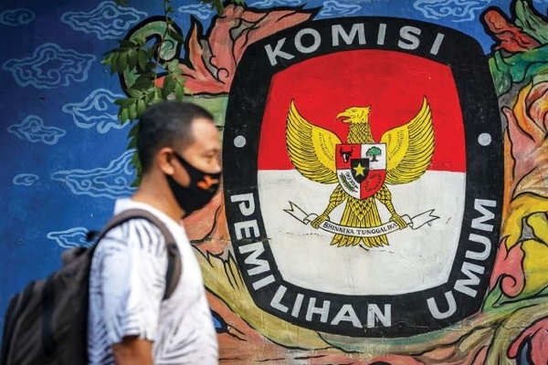 Warga melintas di depan mural logo Komisi Pemilihan Umum (KPU) di kawasan Pasar Anyar, Kota Tangerang, Banten, Kamis (7/5).
