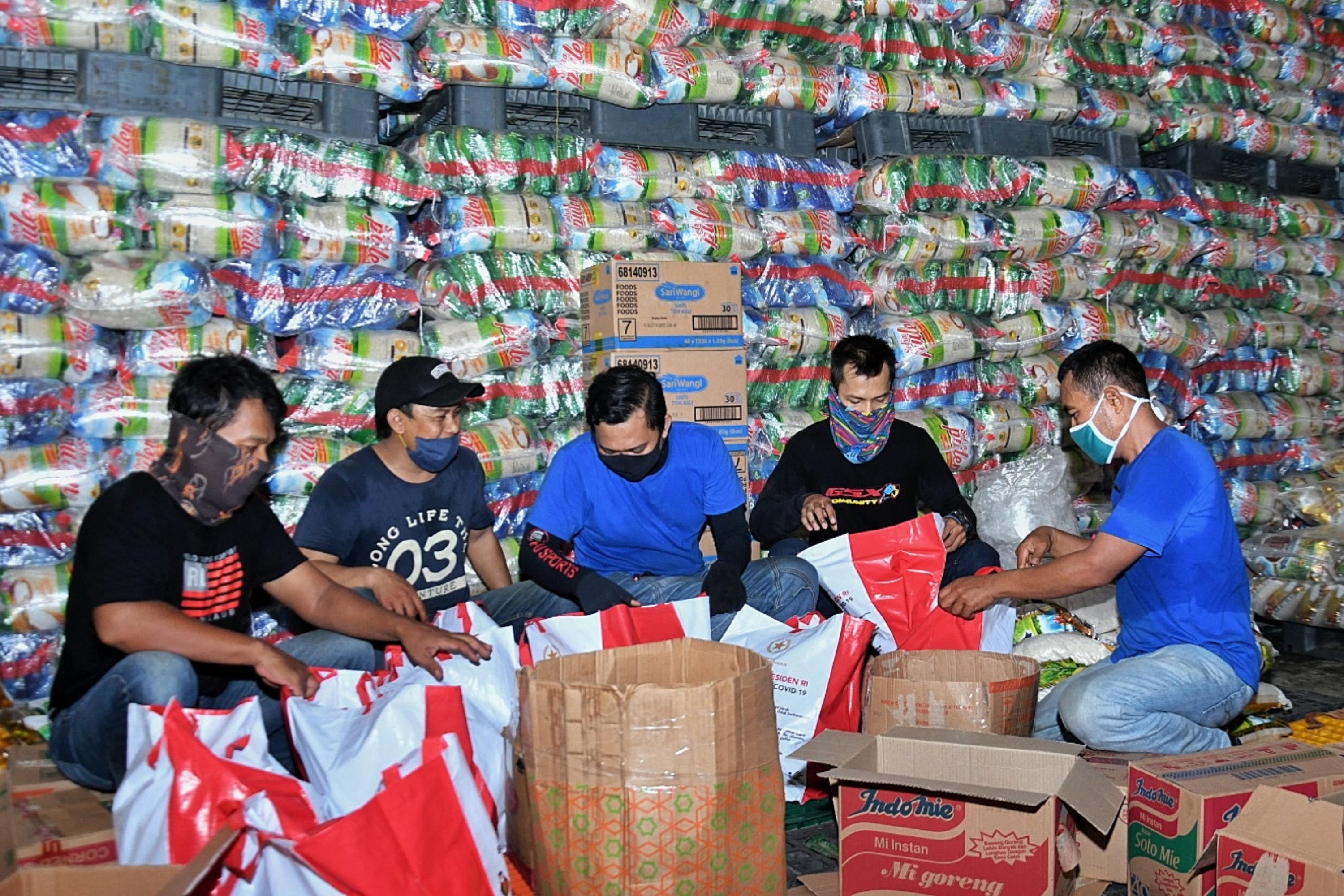 Sejumlah orang mengemas paket bansos di Gudang Food Station Cipinang, Jakarta.