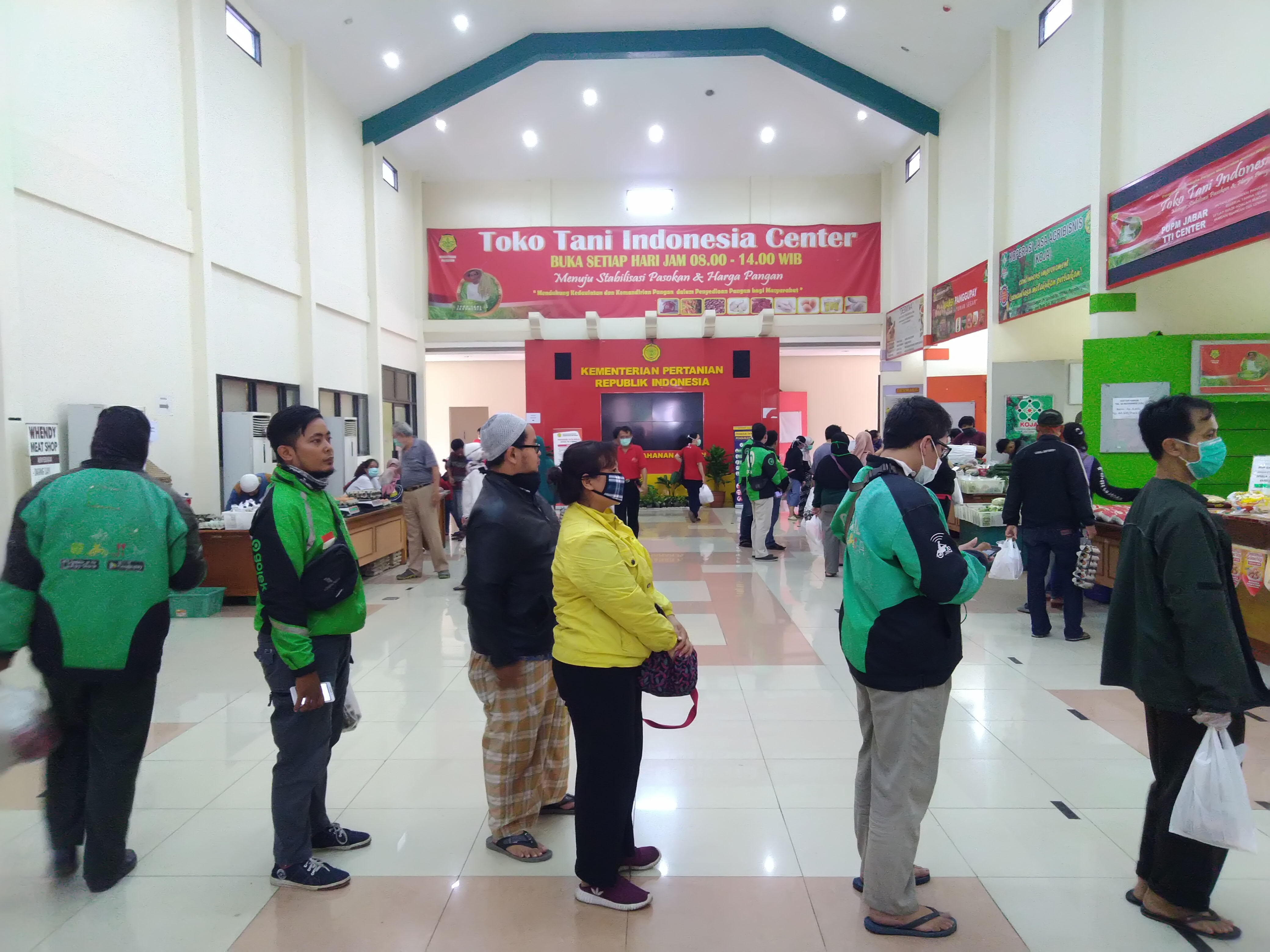 Warga dan pengemudi ojek daring antre membeli bahan makanan di Toko Tani Indonesia Center (TTIC) Pasar Minggu, Jakarta