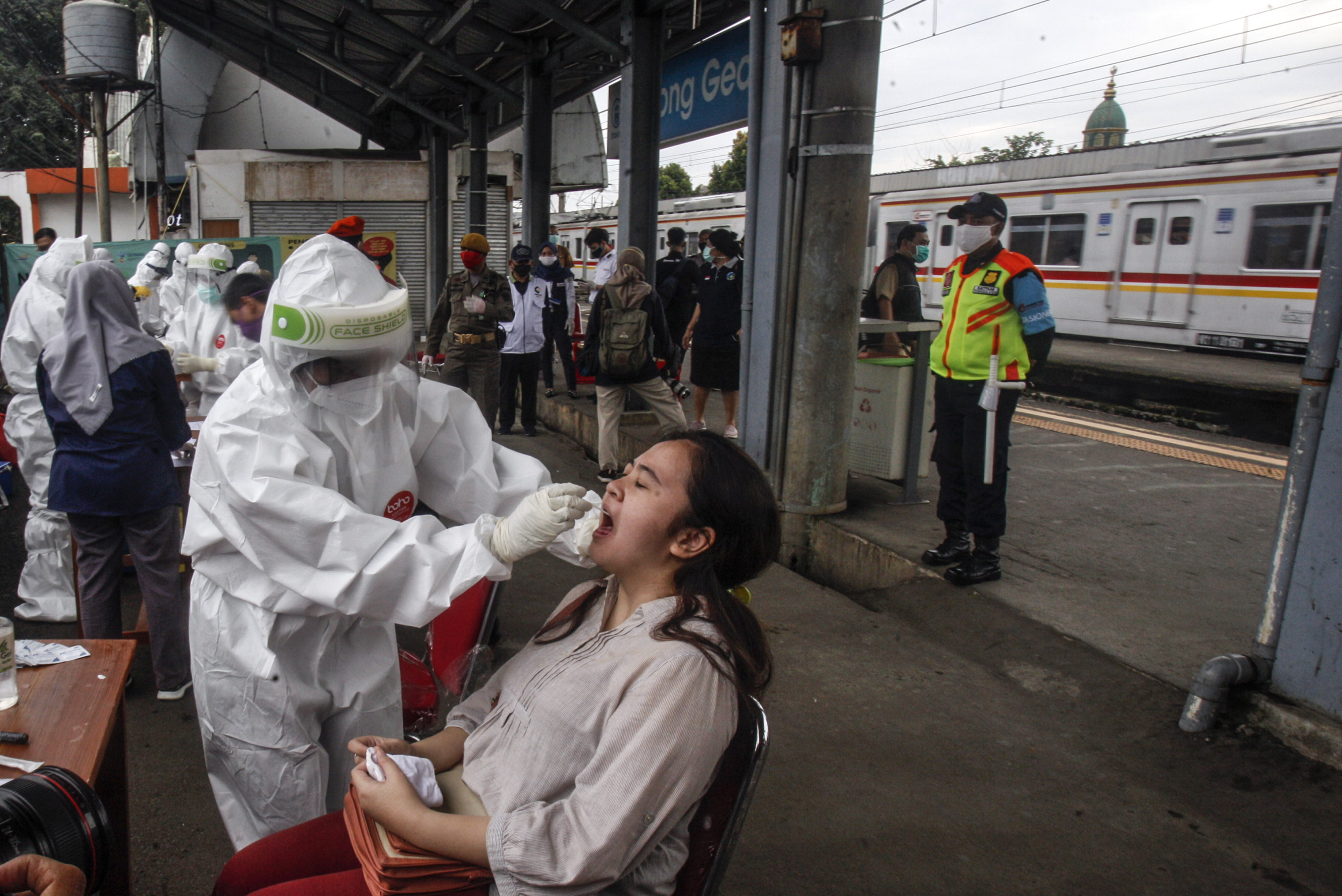 Petugas medis mengambil sampel lendir dari seorang penumpang KRL saat tes swab COVID-19 di Stasiun Bojong Gede, Bogor, Jabar, Senin (11/5).