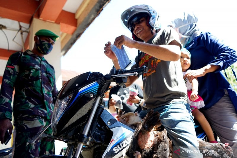 eorang anggota TNI menghentikan warga yang tidak mengenakan masker di pos penguatan Pembatasan Sosial Berskala Besar (PSBB).
