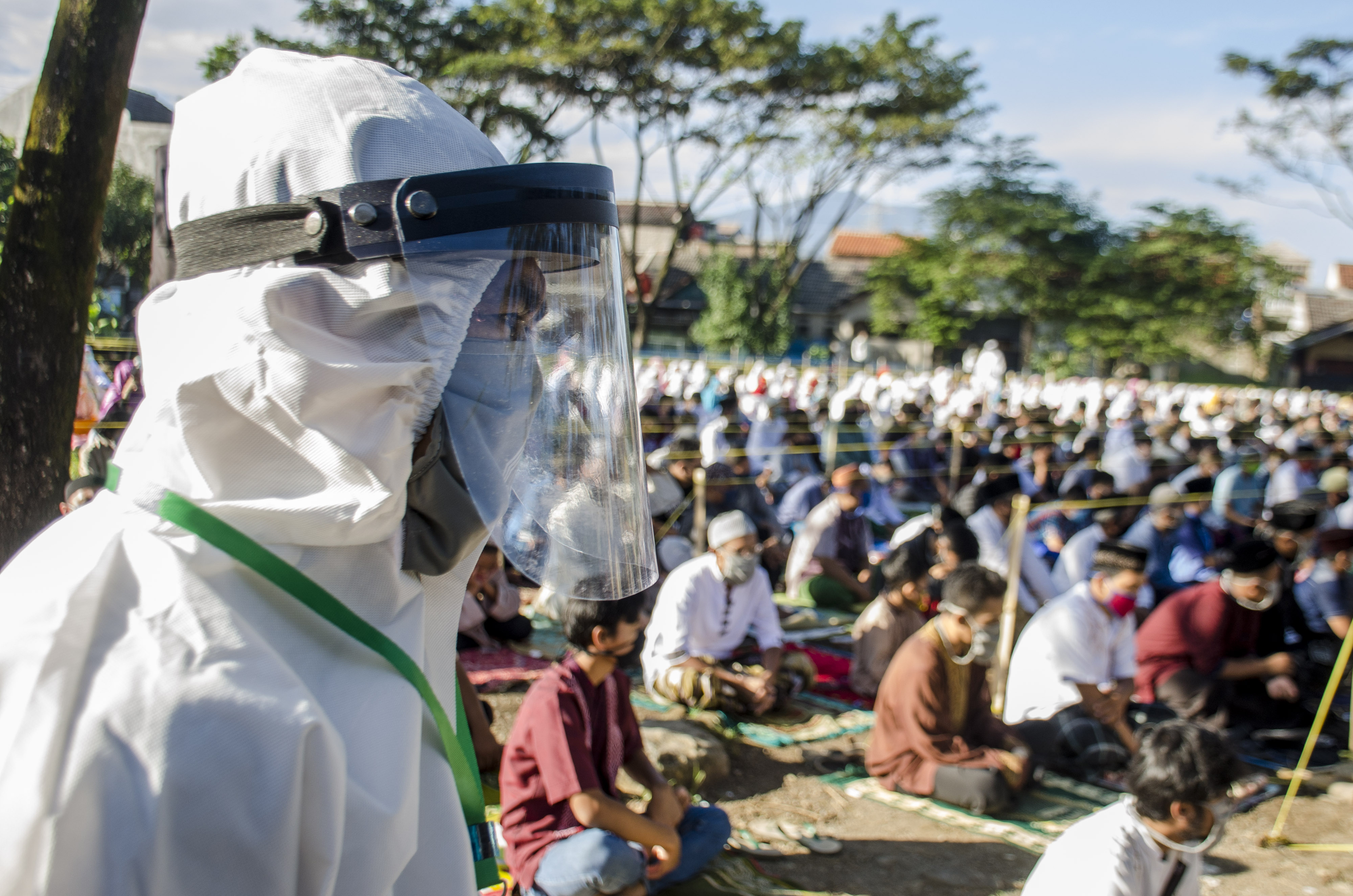 Seorang Panitia menggunakan APD lengkap saat memantau kondisi warga dalam pelaksanaan Salat Id di Baleendah, Kabupaten Bandung, Jawa Barat.
