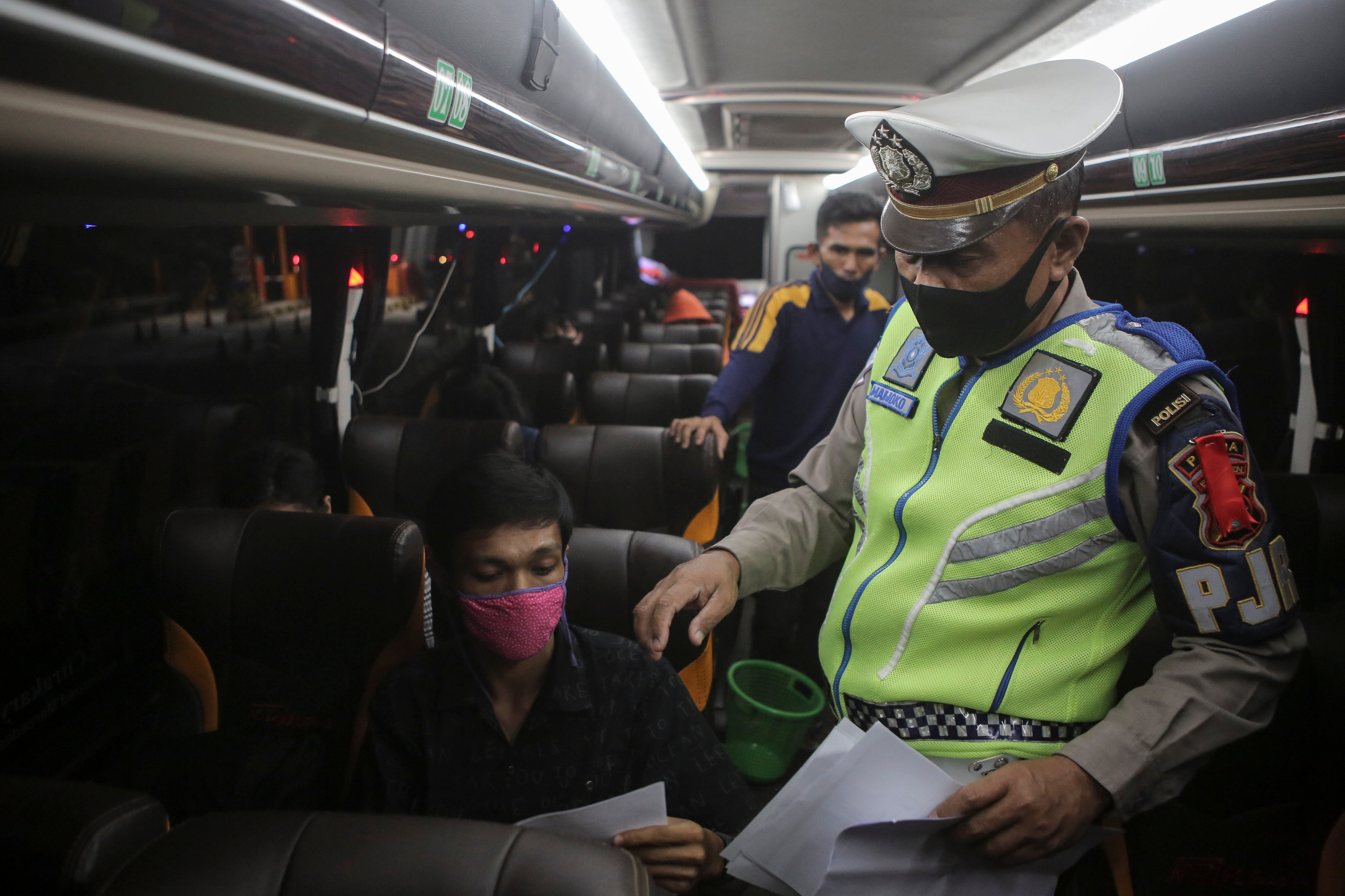 Petugas Kepolisian melakukan pemeriksaan surat-surat dan barang bawaan penumpang kendaraan pribadi dan umum di gerbang tol Merak, Banten.