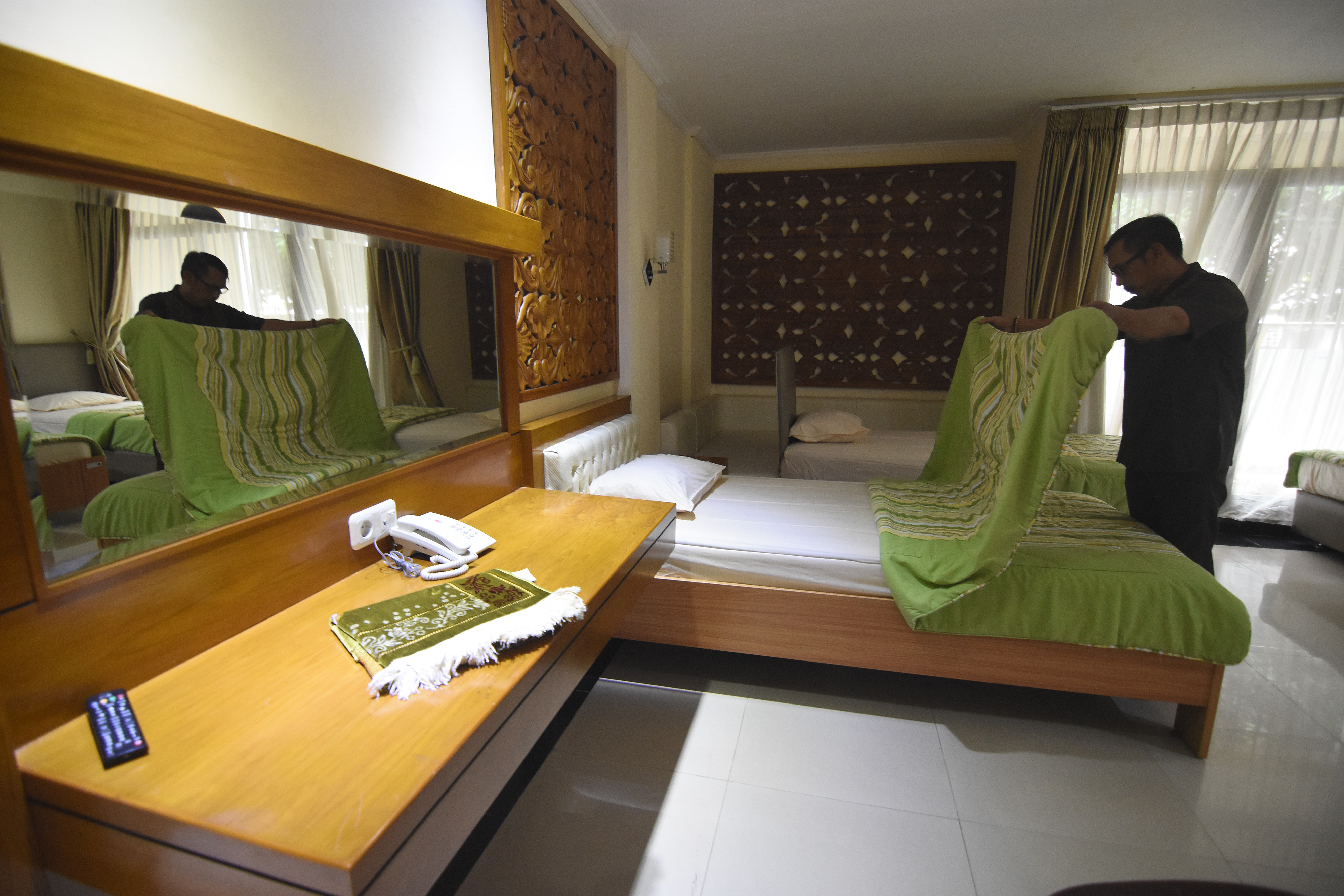 Petugas merapikan kamar di Asrama Haji Pondok Gede, Jakarta.