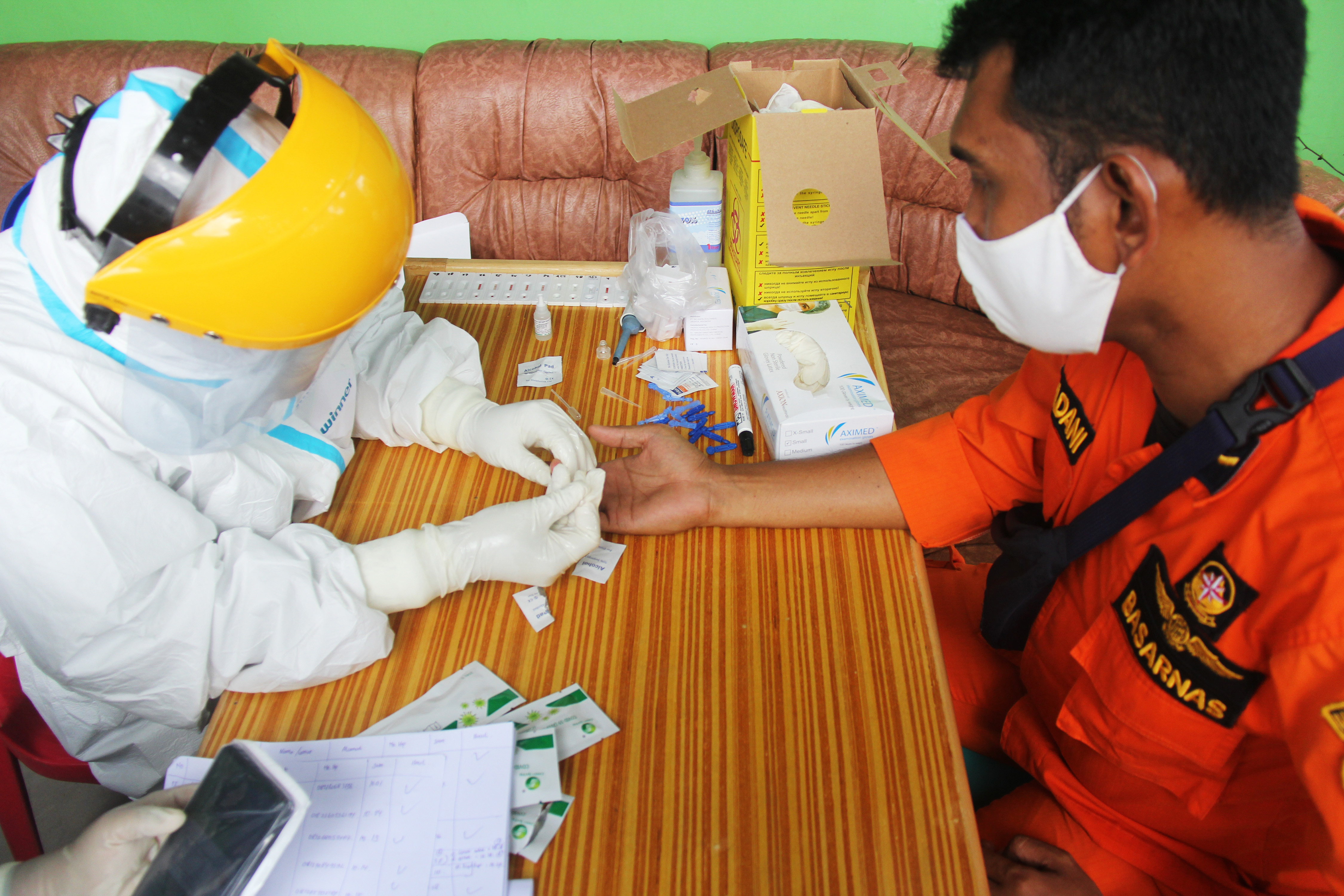 Petugas medis mengambil sampel darah seorang anggota Basarnas saat melakukan rapid test covid-19 di Kota Dumai, Riau.