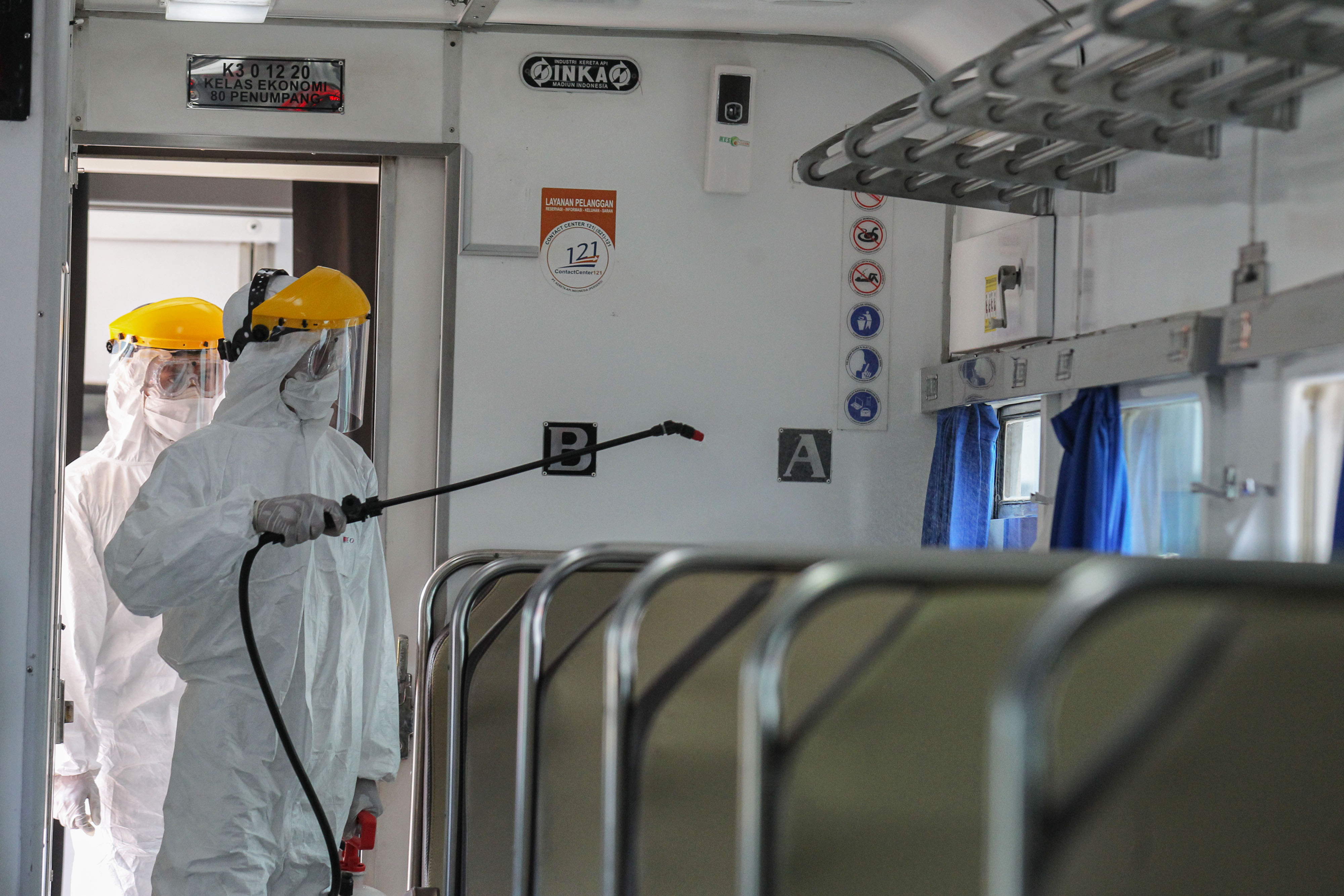  Petugas menyemprotkan cairan disinfektan dalam gerbong kereta api jarak jauh yang sedang dalam proses pembersihan di Stasiun Pasar Senen 
