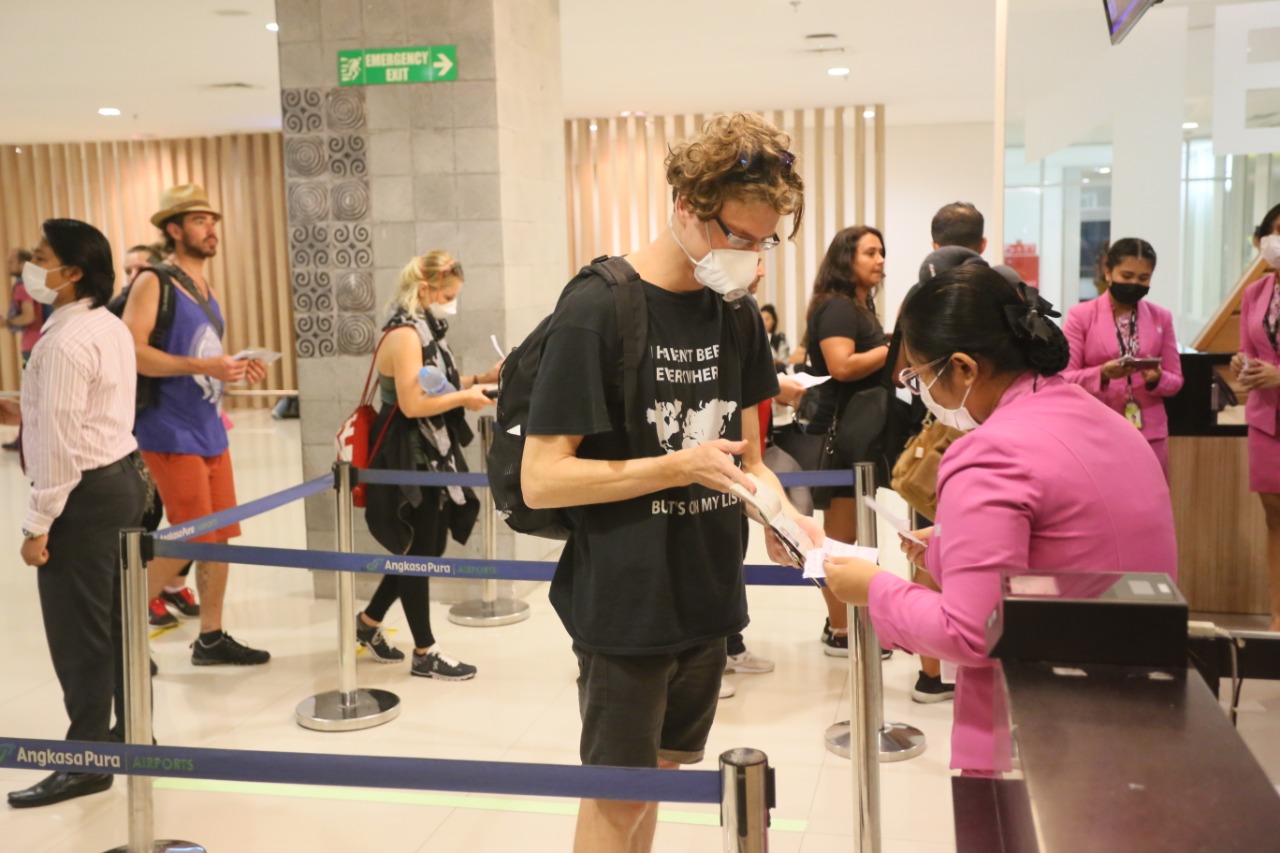 Petugas melayani wisatawan yang tiba di Bandara Ngurah Rai, Denpasar, Bali.