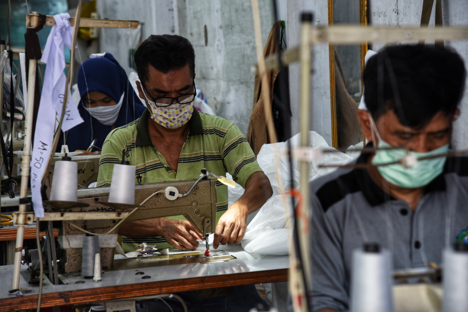 Pekerja konveksi menyelesaikan pekerjaan di tengan pandemi covid-19