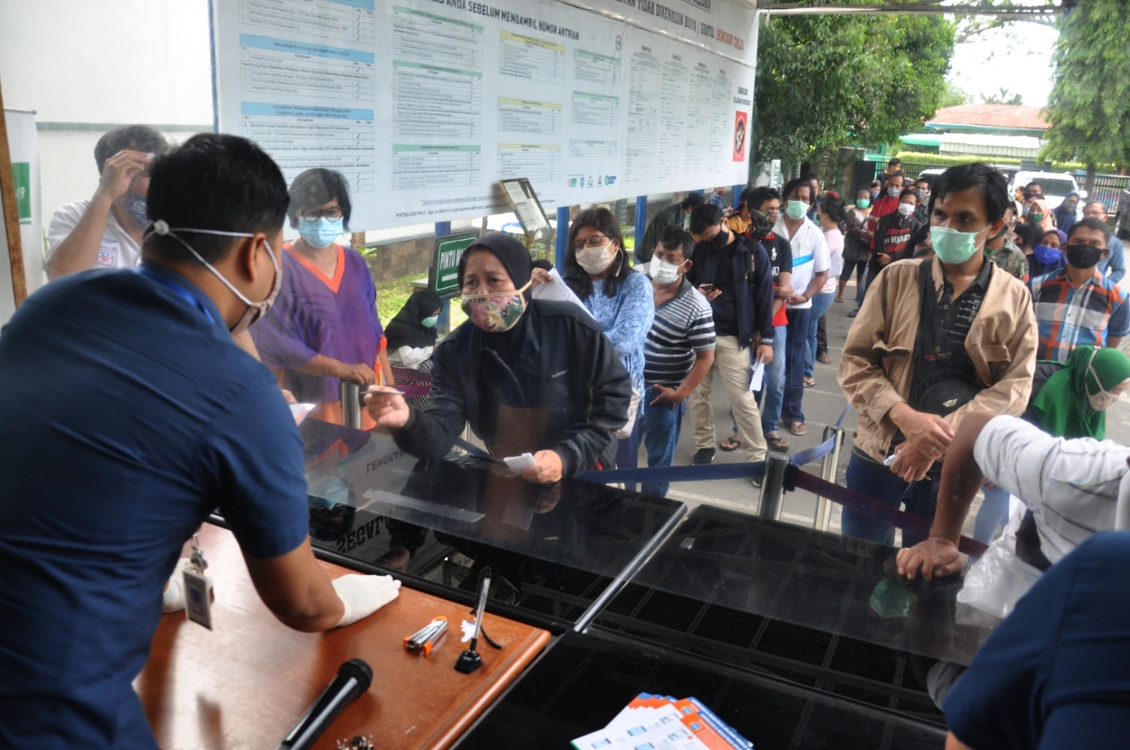 Pegawai BPJS melayani sejumlah warga di kantor Badan Penyelenggaraan Jaminan Sosial (BPJS) Cabang Medan, Sumatera Utara, hari ini.