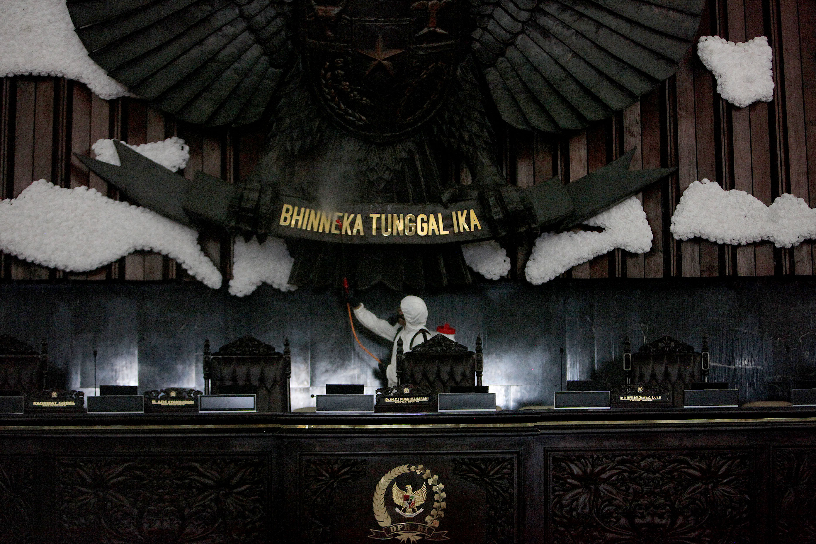 Petugas melakukan penyemprotan disinfektan di area Gedung Paripurna, Nusantara I, Kompleks Parlemen Senayan, Jakarta, Minggu (29/3).