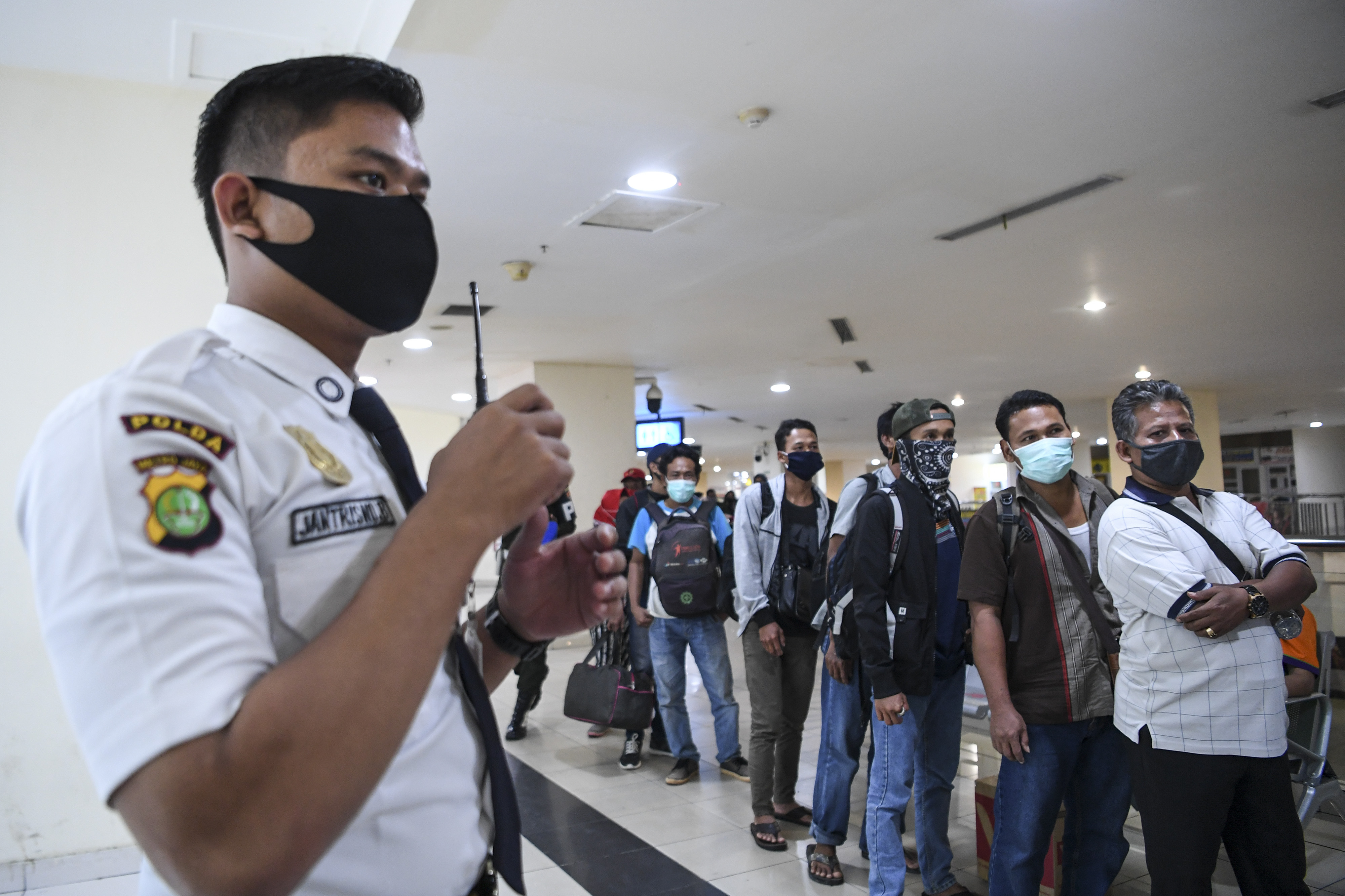 Calon penumpang yang akan berpergian menggunakan Bus AKAP mengantre untuk diperiksa dokumennya di Terminal Pulogebang, Jakarta.