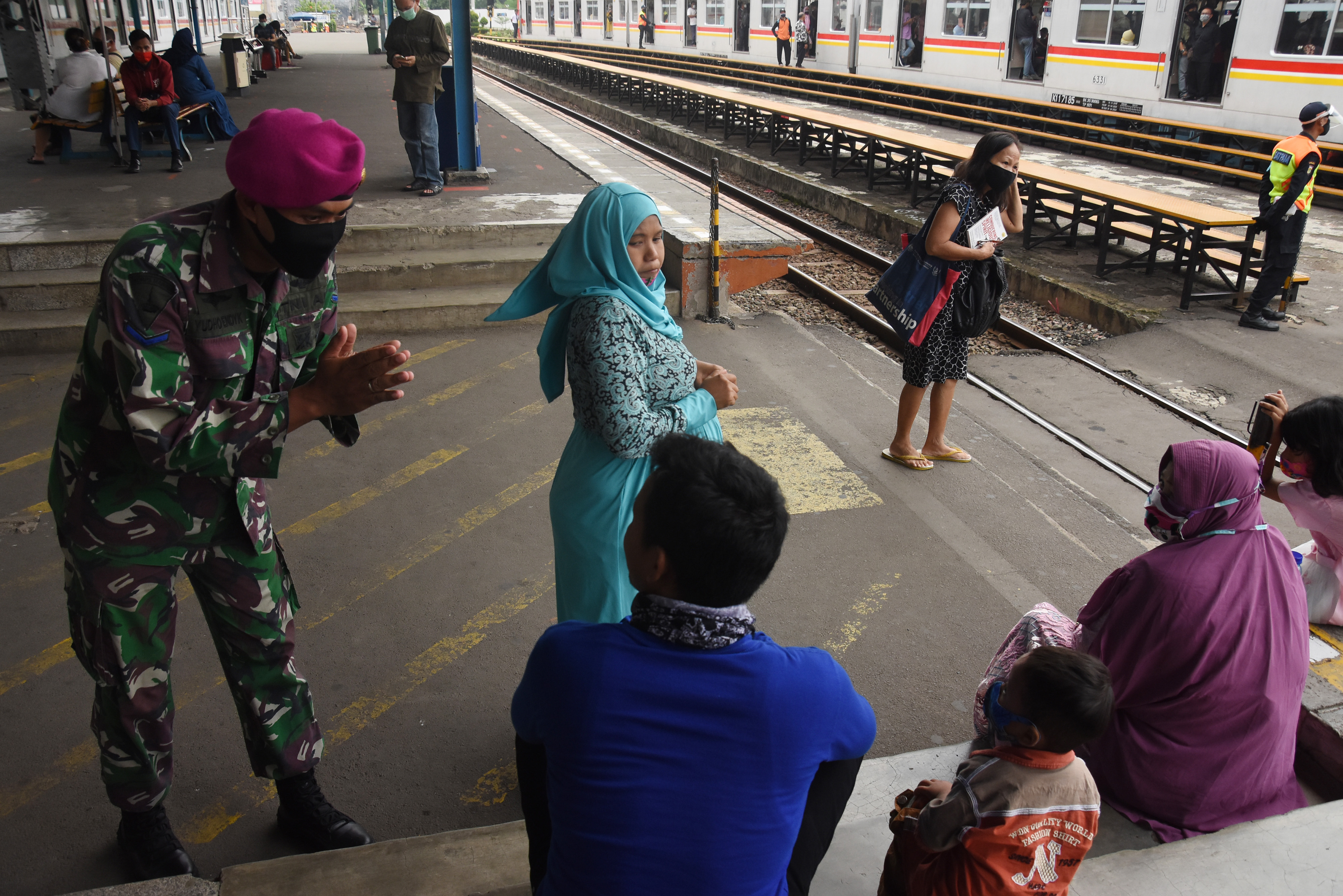 Anggota TNI memberikan imbauan pendisiplinan protokol kesehatan pencegahan COVID-19 kepada penumpang KRL di Stasiun Manggarai, Jakarta.
