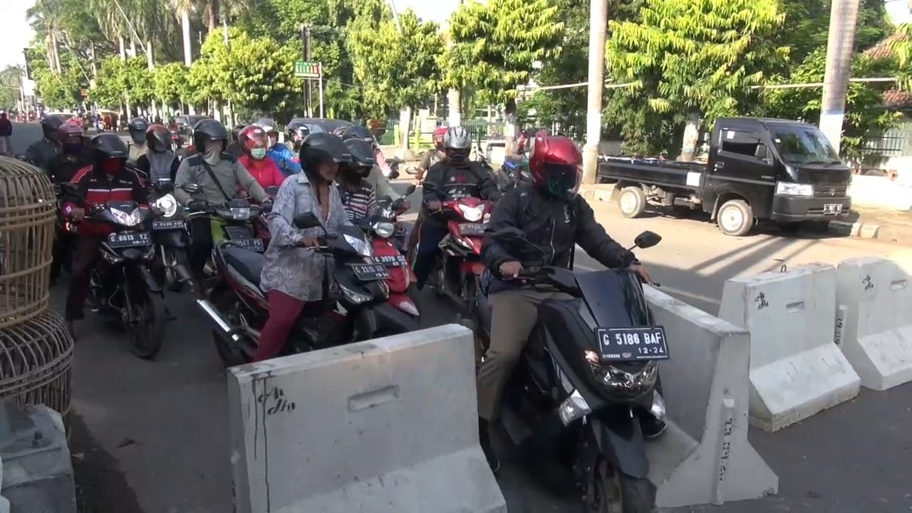 Para pemotor menerobos barikade beton di Jl. Sultan Agung, Kota Tegal, Jawa Tengah. Pembatas beton akan dibuka pada 15 Mei 2020.