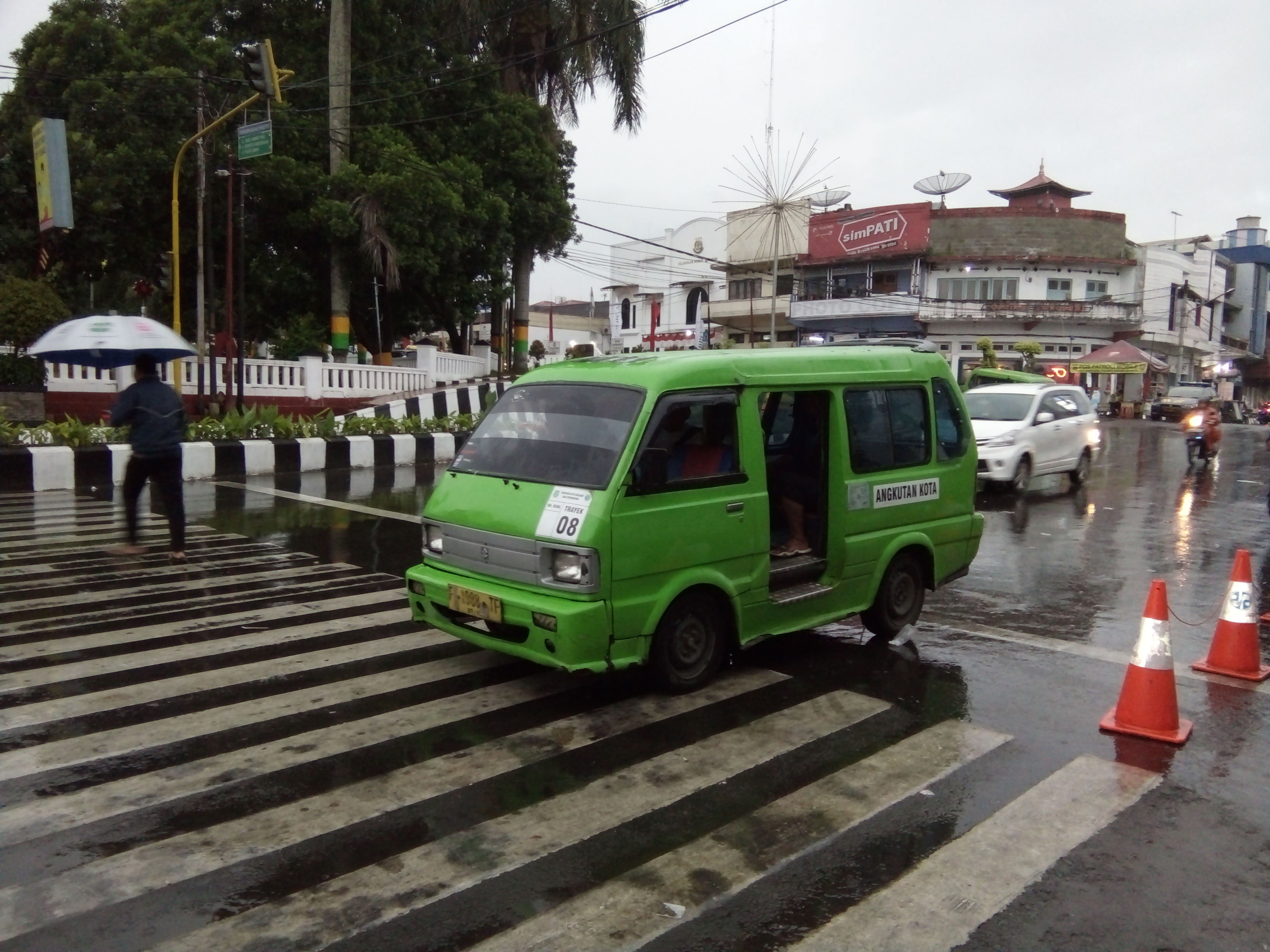 Angkutan kota melintasi di ruas Jalan Ahmad Yani Kota Sukabumi, Jawa Barat.