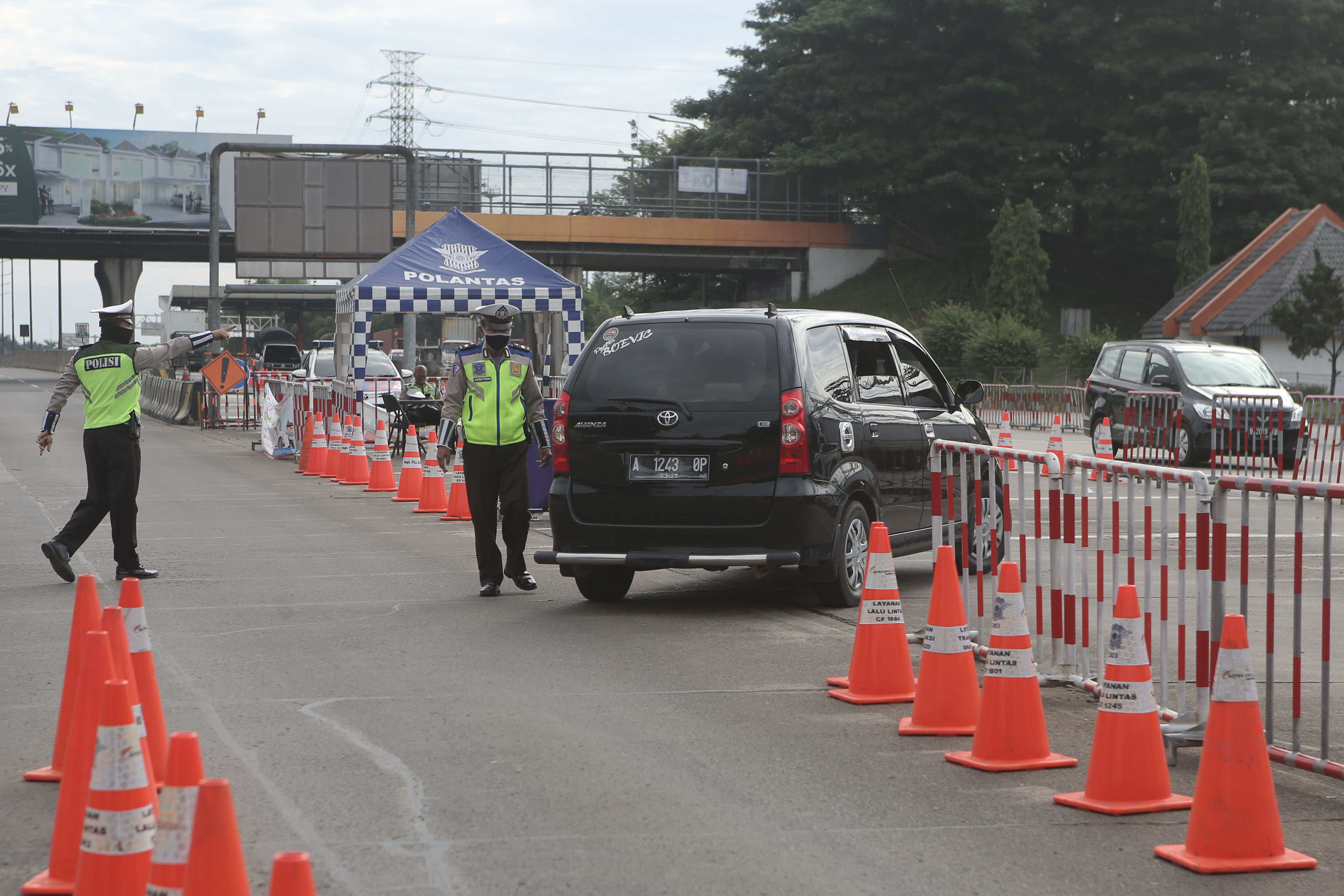 Petugas Kepolisian memerintahkan pengemudi putar arah kembali ke Jakarta di Gerbang Tol Cikupa (21/5/2020)