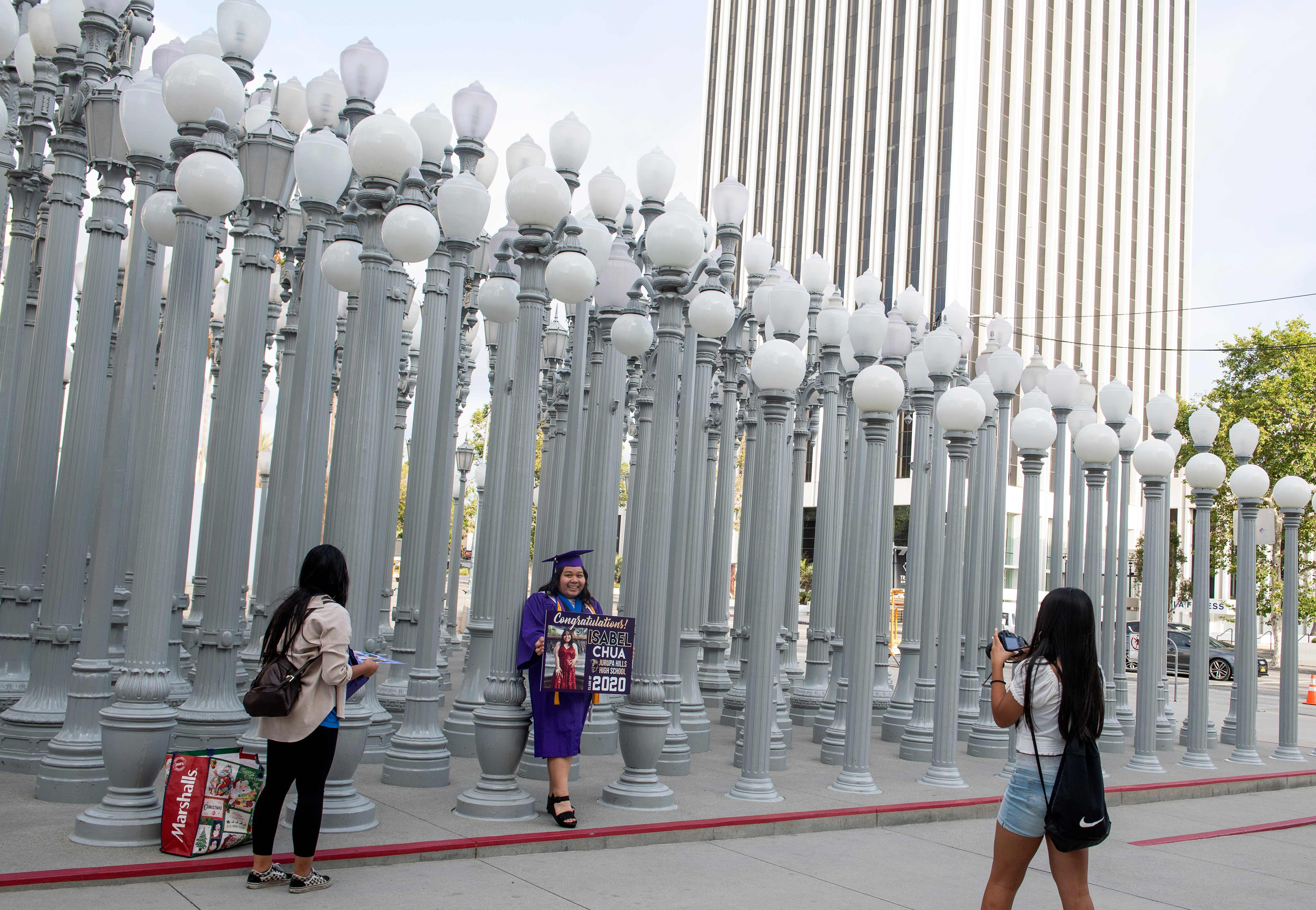 Seorang siswa berpose usai kelulusan di depan Museum LACMA yang kini ditutup untuk umum. Sejumah museum di dunia terancam tutup permanen.