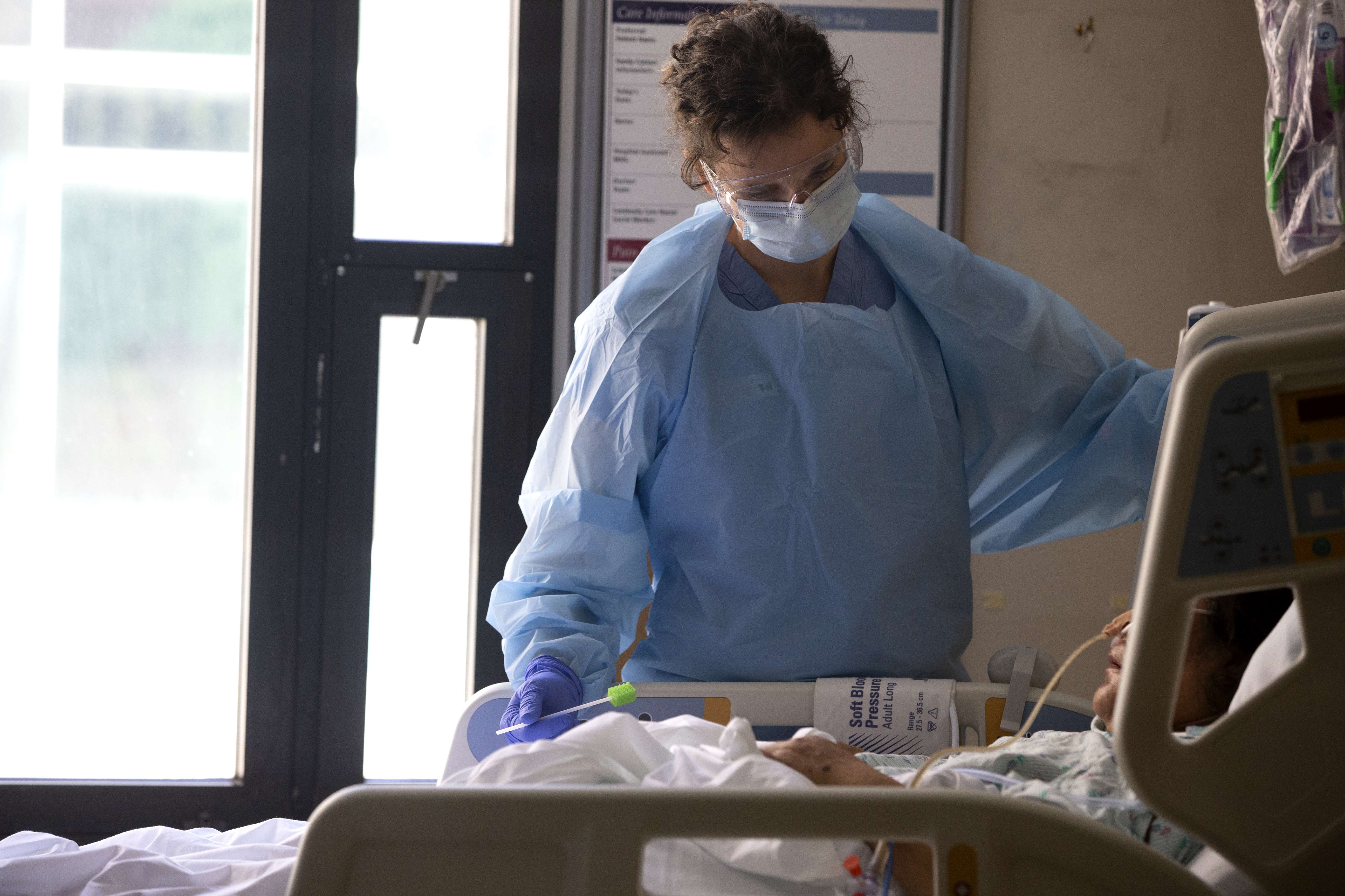 Perawat Karen Hayes memberikan perawatan kepada pasien covid-19 di Harborview Medical Center di Seattle, Washington, Kamis (7/5).