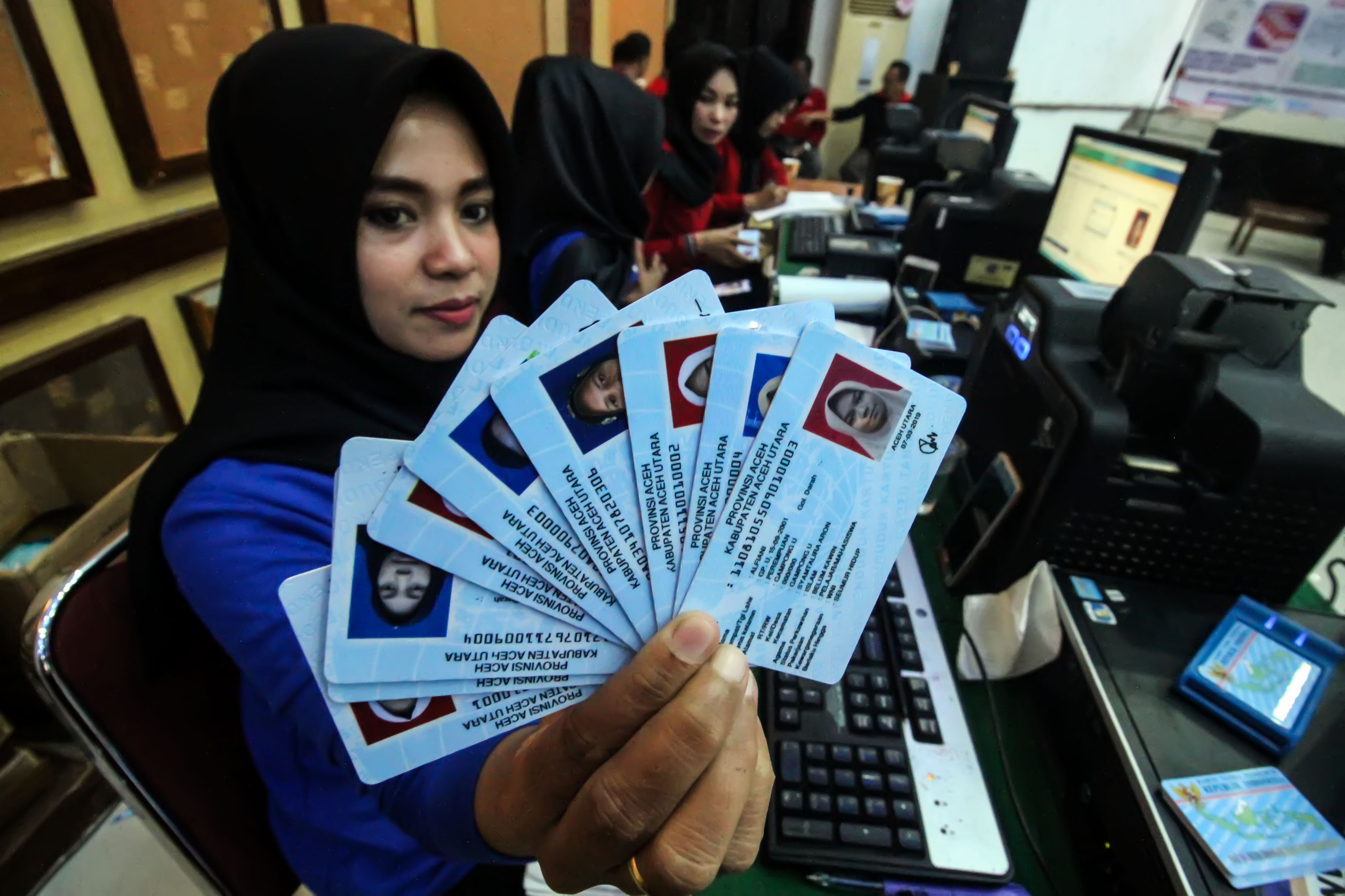 Petugas menunjukkan Kartu Tanda Penduduk elektronik (e-KTP)