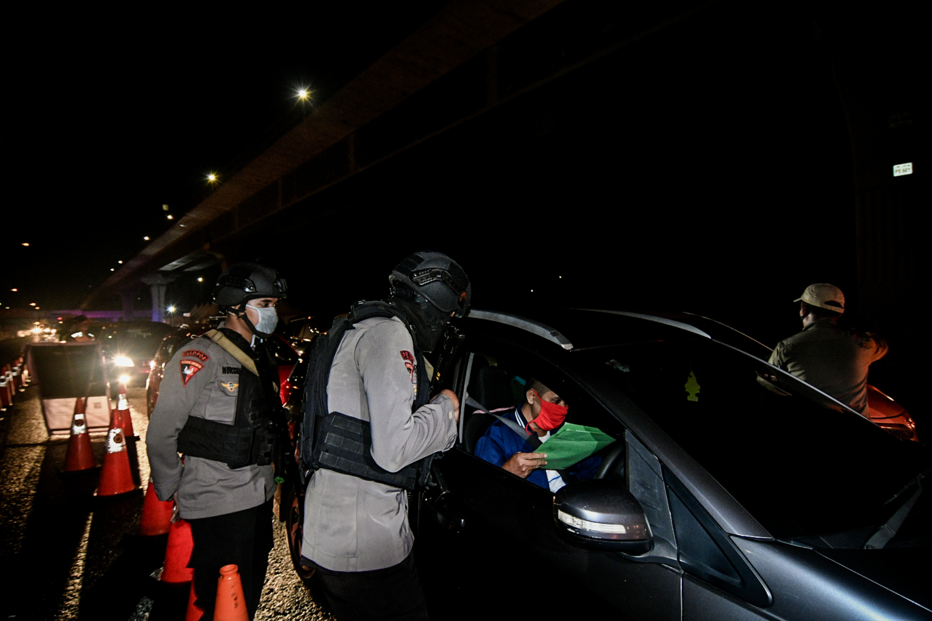 Petugas memeriksa surat izin keluar masuk (SIKM) untuk masuk wilayah Jabodetabek di KM 47 Tol Cikampek-Jakarta, Jawa Barat, Rabu (27/5).