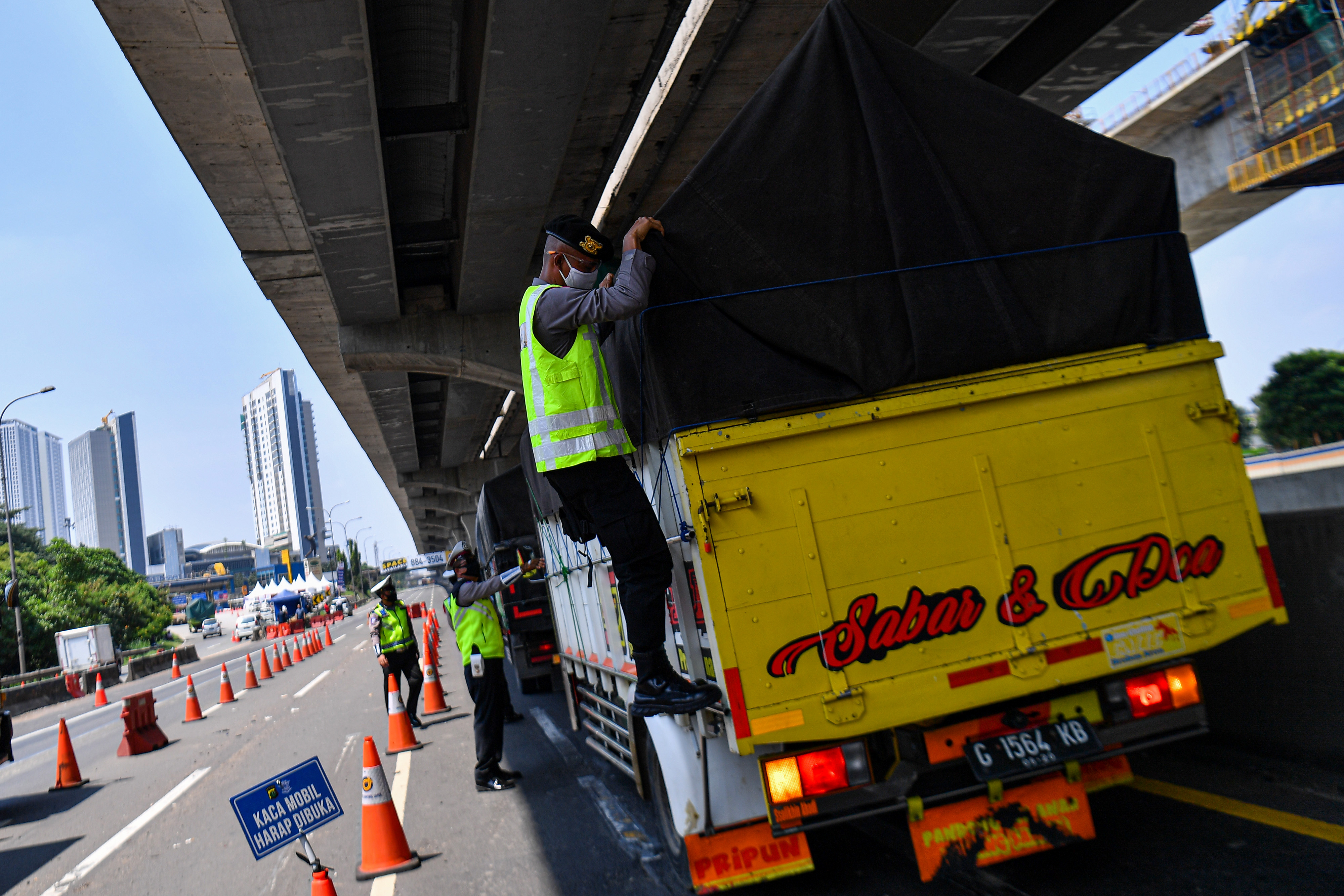 Petugas kepolisian memeriksa bak truk di jalan tol Jakarta-Cikampek, Cikarang Barat, Jawa Barat, Kamis (7/5). 