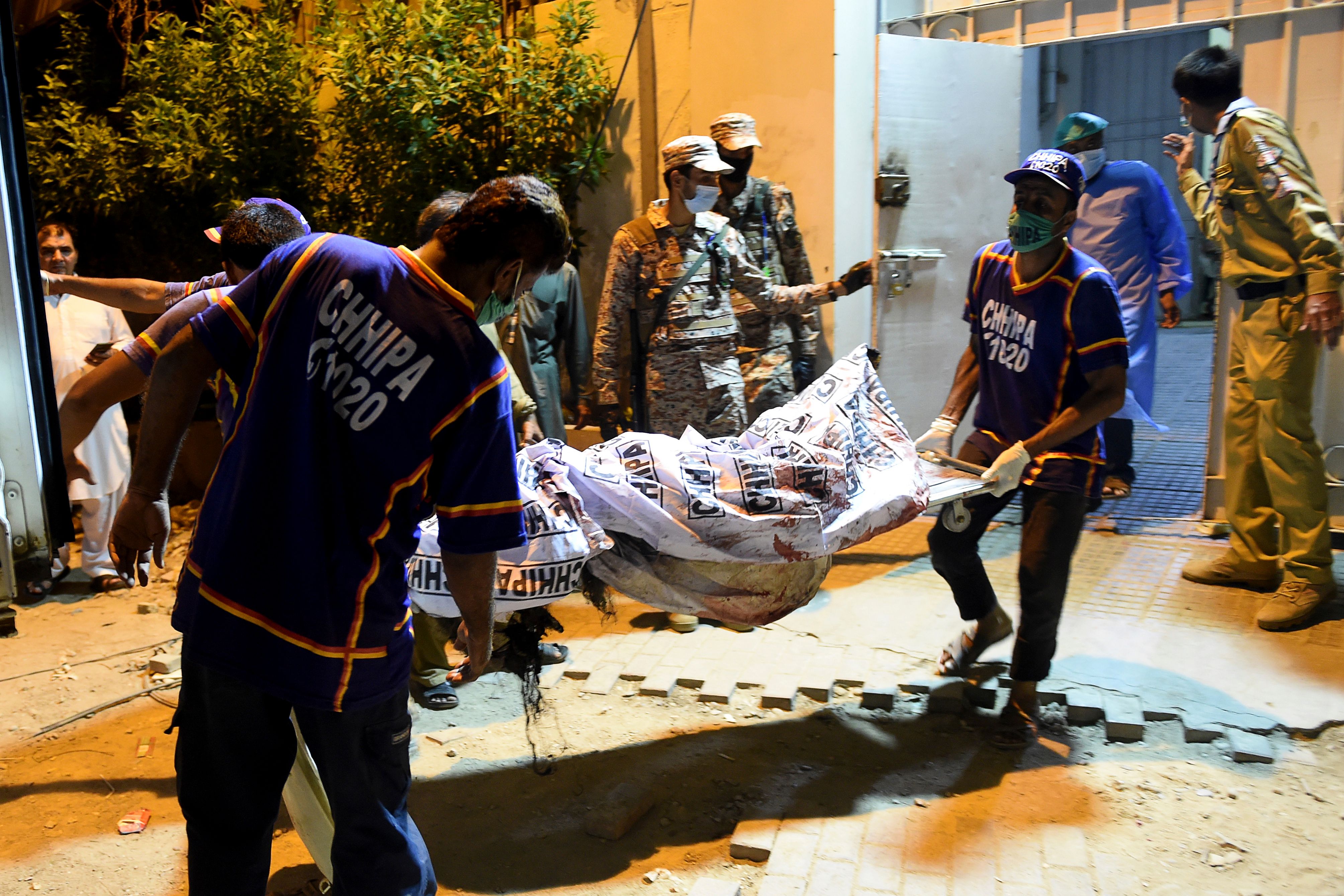 Petugas membawa jenazah korban kecelakaan pesawat terbang di Pakistan, Jumat (22/5).