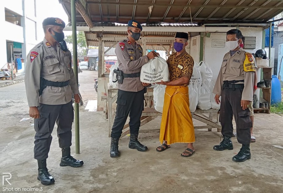 Anggota Resimen 1 Pasukan Pelopor Brimob Polri memberikan bantuan kepada masyarakat.