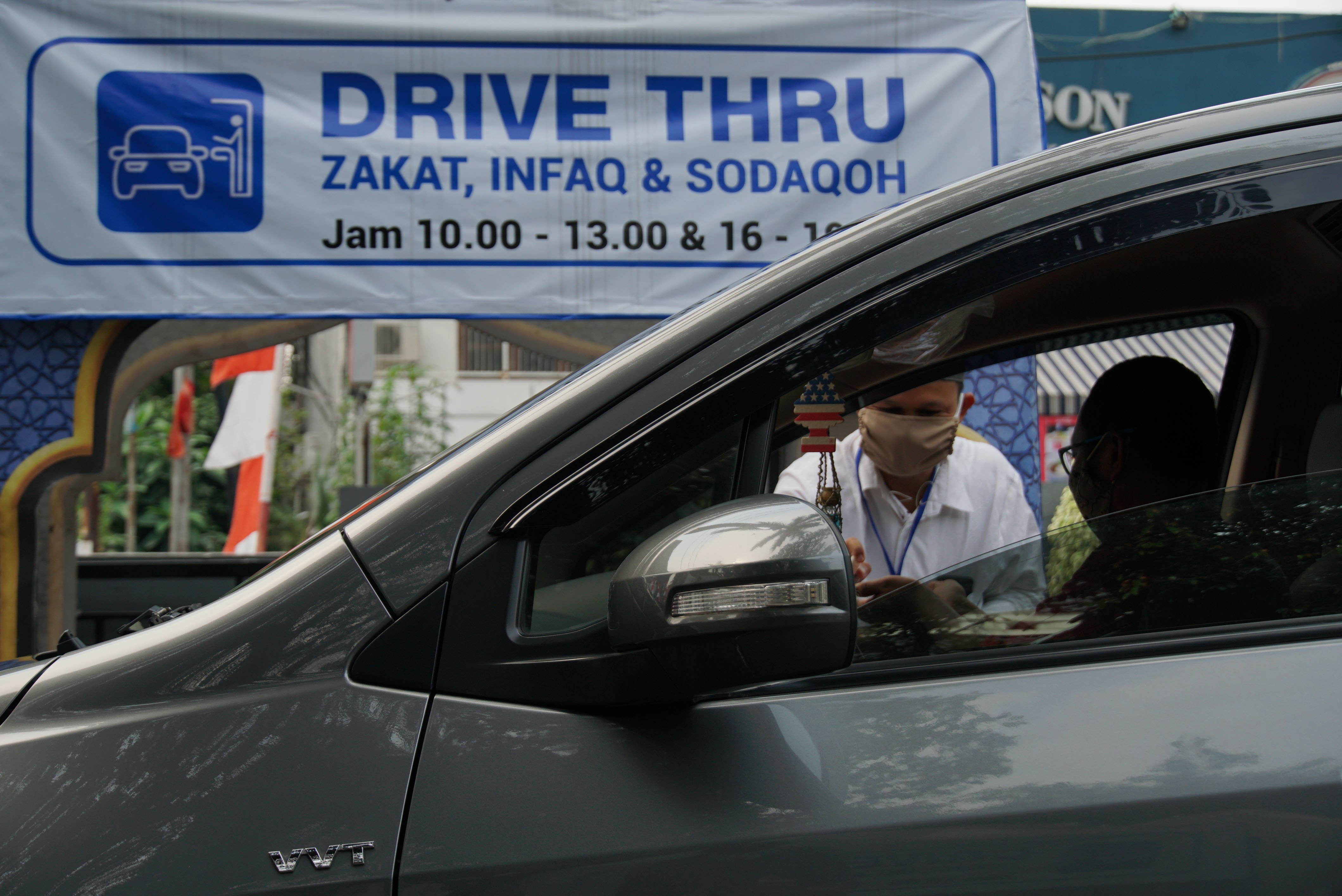 Petugas Amil Zakat menerima pembayaran Zakat melalui sistem Drive Thru atau layanan tanpa turun dari kendaraan.