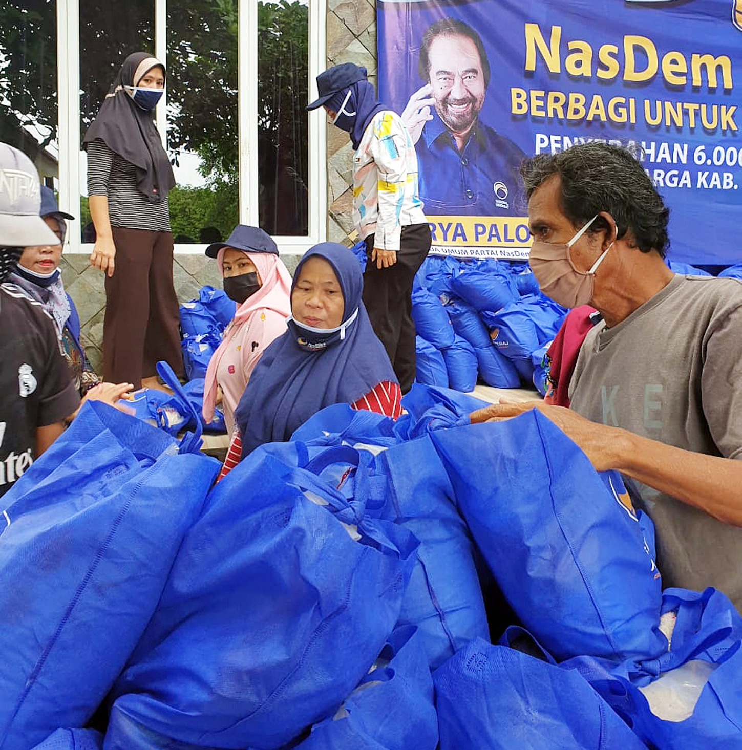 Masyarakat menerima bantuan paket sembako yang dibagikan Partai NasDem di Pulau Kelapa, Kepulauan Seribu, kemarin. 
