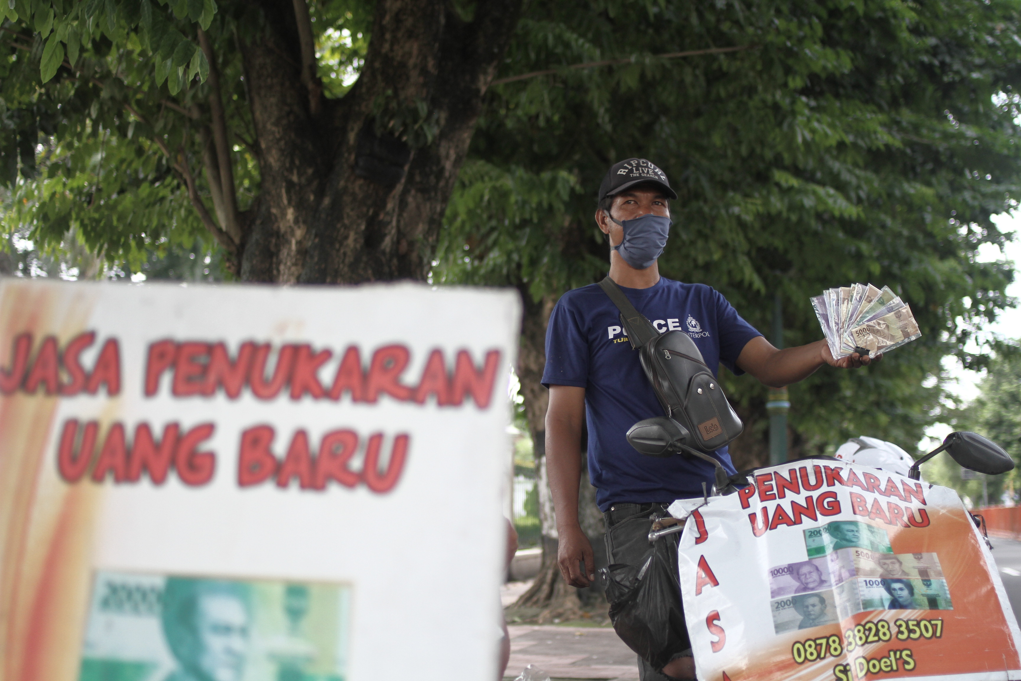 Penjual jasa penukaran uang menunggu pembeli di kawasan Titik Nol Kilometer, DI Yogyakarta, Kamis (14/5).