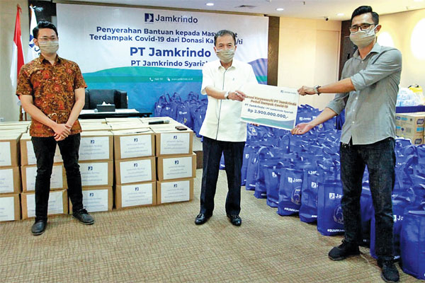 Direktur Utama Jamkrindo, Randi Anto, (tengah) menyerahkan bantuan yang berasal dari donasi direksi dan karyawan PT Jamkrindo