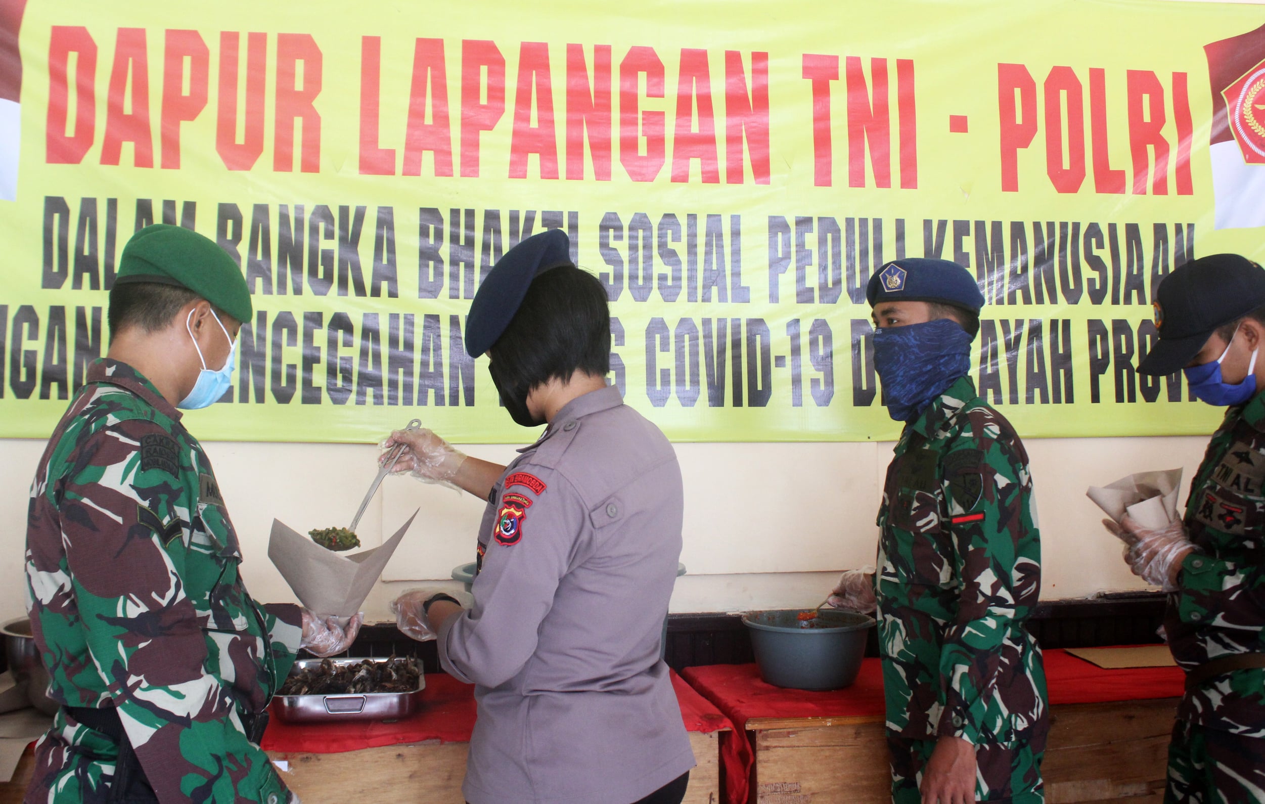 Anggota Brimob Polda NTT bersama anggota TNI menyiapkan makanan yang akan dibagikan kepada warga terdampak covid-19.