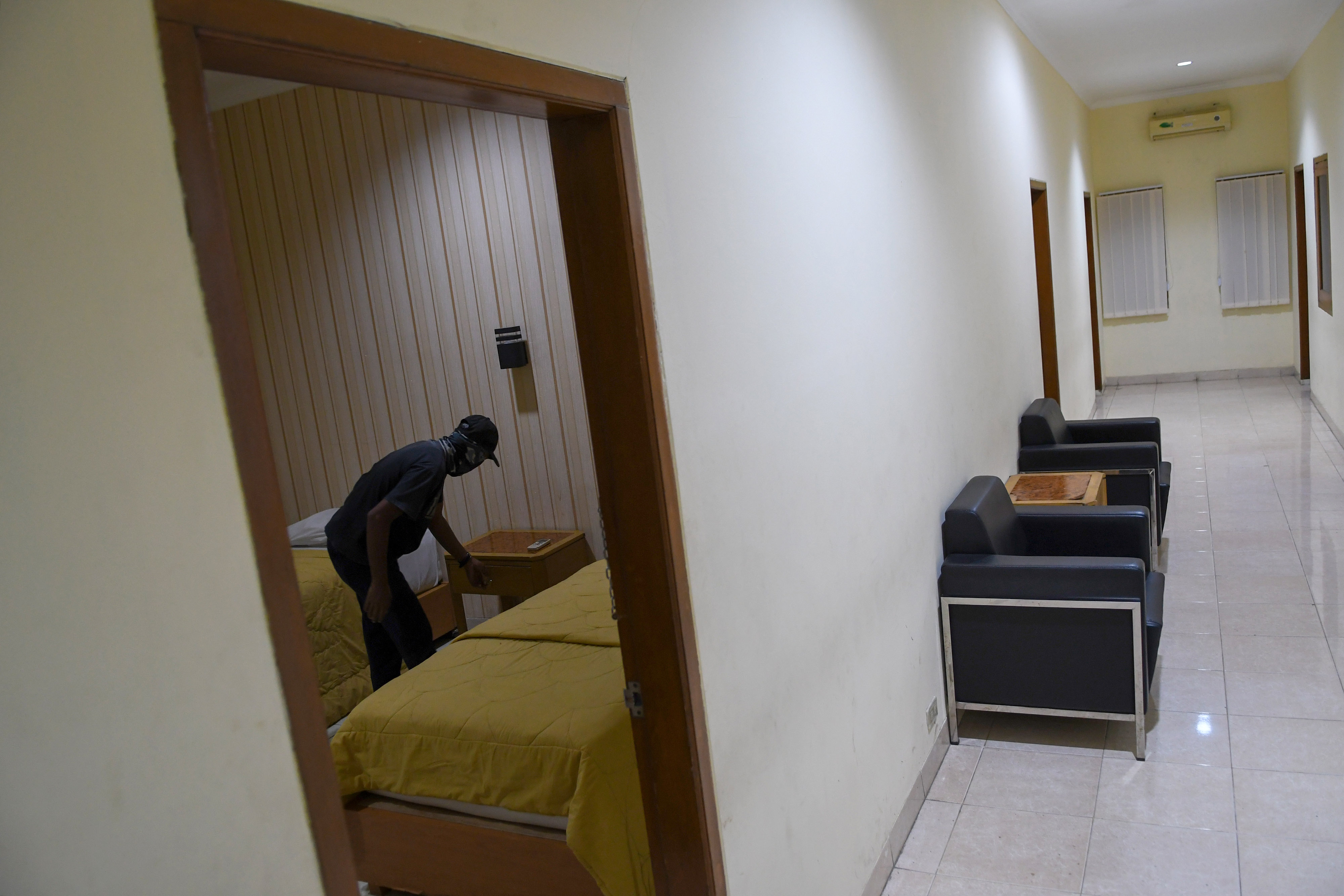 Seorang karyawan memeriksa ruangan tempat tinggal di SMK Negeri 27 Jakarta yang akan digunakan untuk isolasi pasien covid-19.