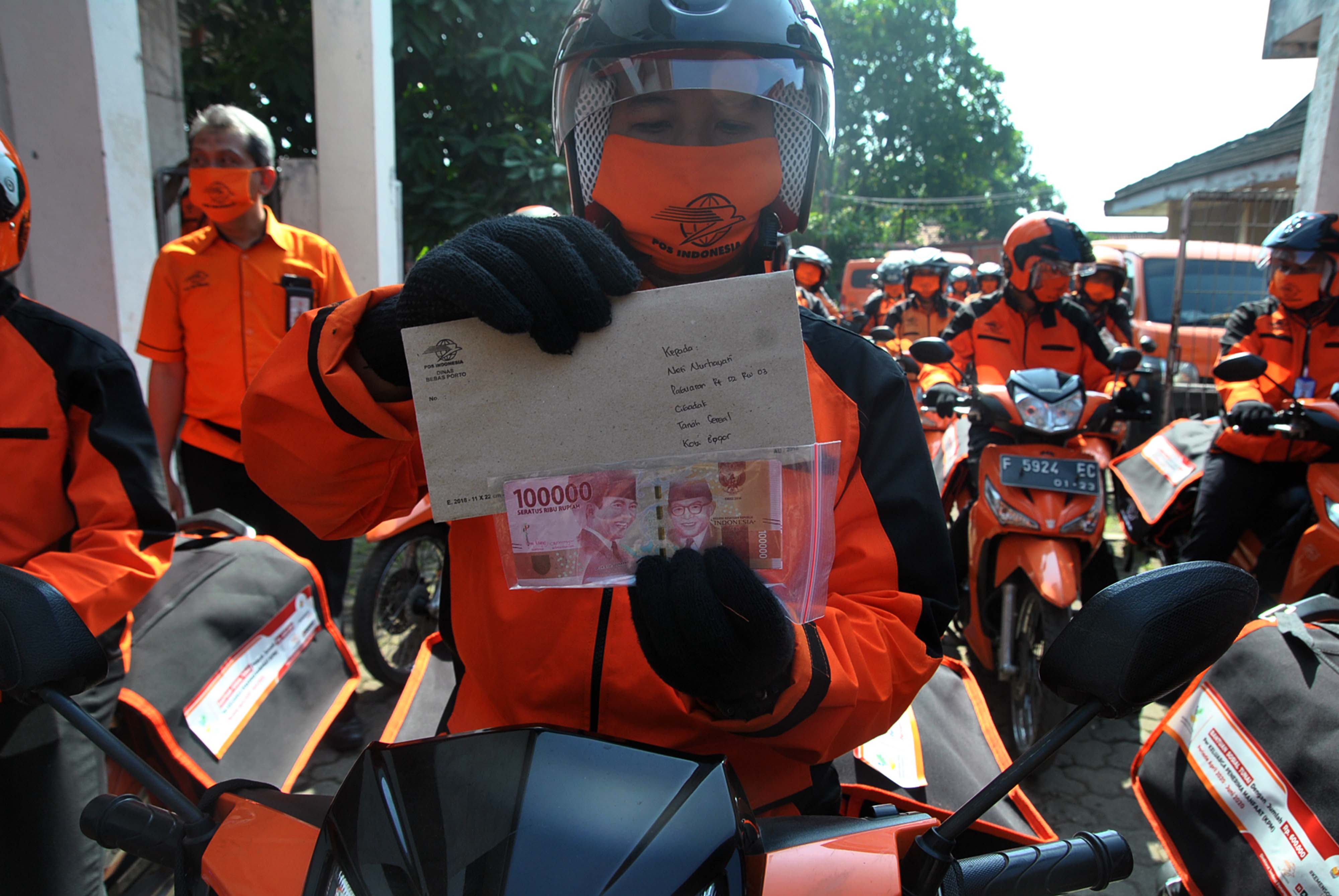 Petugas Pos Indonesia menunjukkan bantuan sosial tunai yang akan disalurkan kepada KPM di Kantor Pos, Kelurah Cibadak, Tanah Sereal, Bogorn 