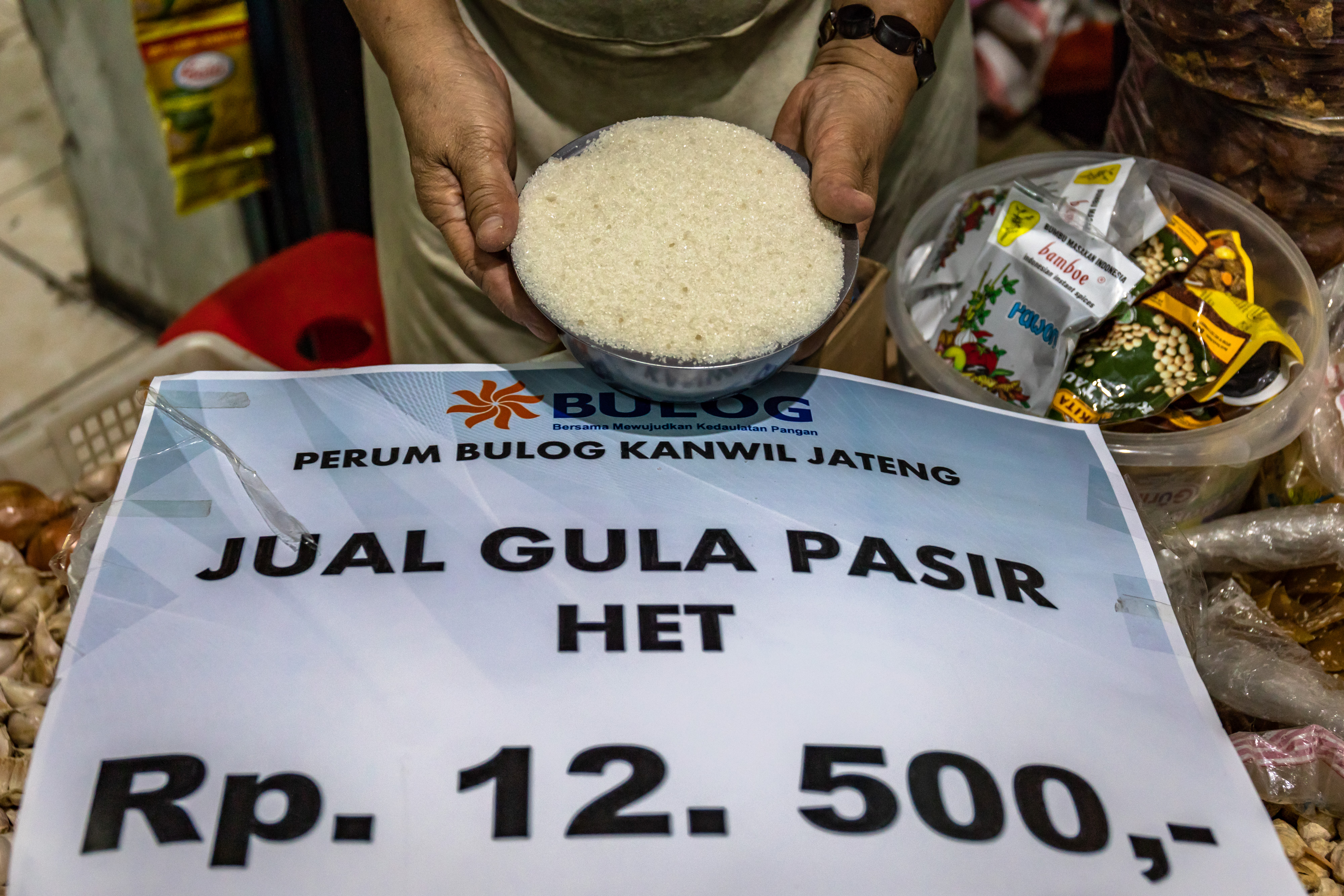 Pedagang di Pasar Bulu Semarang menunjukkan gula pasir dari Bulog saat digelar operasi pasar