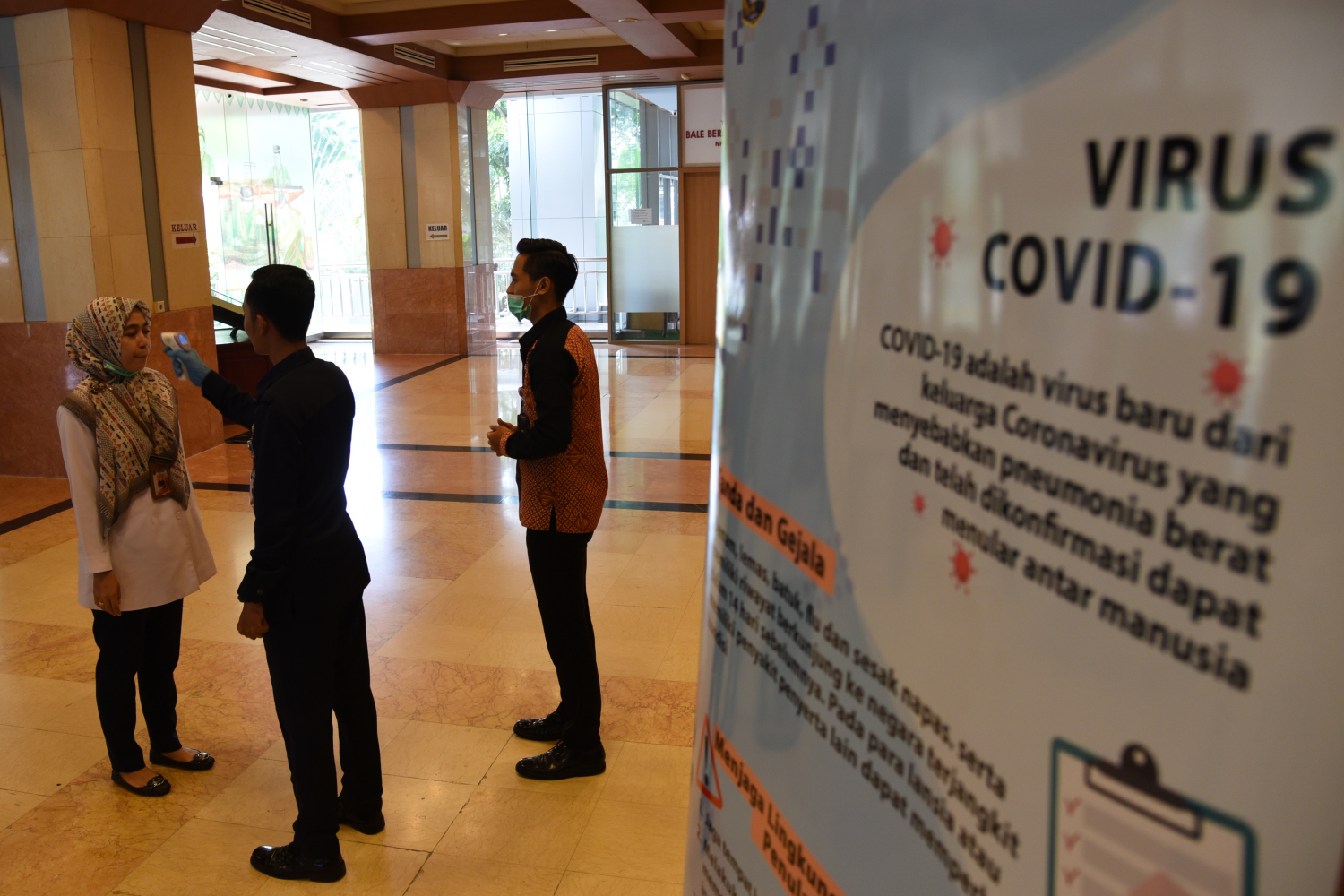 Petugas melakukan pengecekan suhu tubuh bagi para aparatur sipil negara (ASN) maupun warga yang berkunjung ke Gedung Balai Kota, Jakarta.