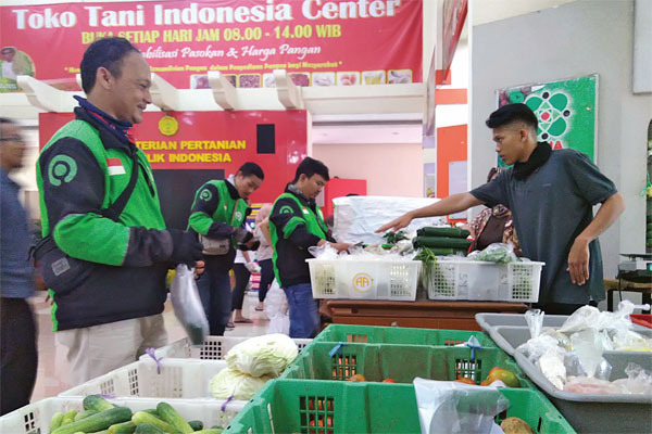BELANJA DARING: Warga dan pengemudi ojek daring antre membeli bahan makanan di Toko Tani Indonesia Center (TTIC) Pasar Minggu, di Jakarta, 
