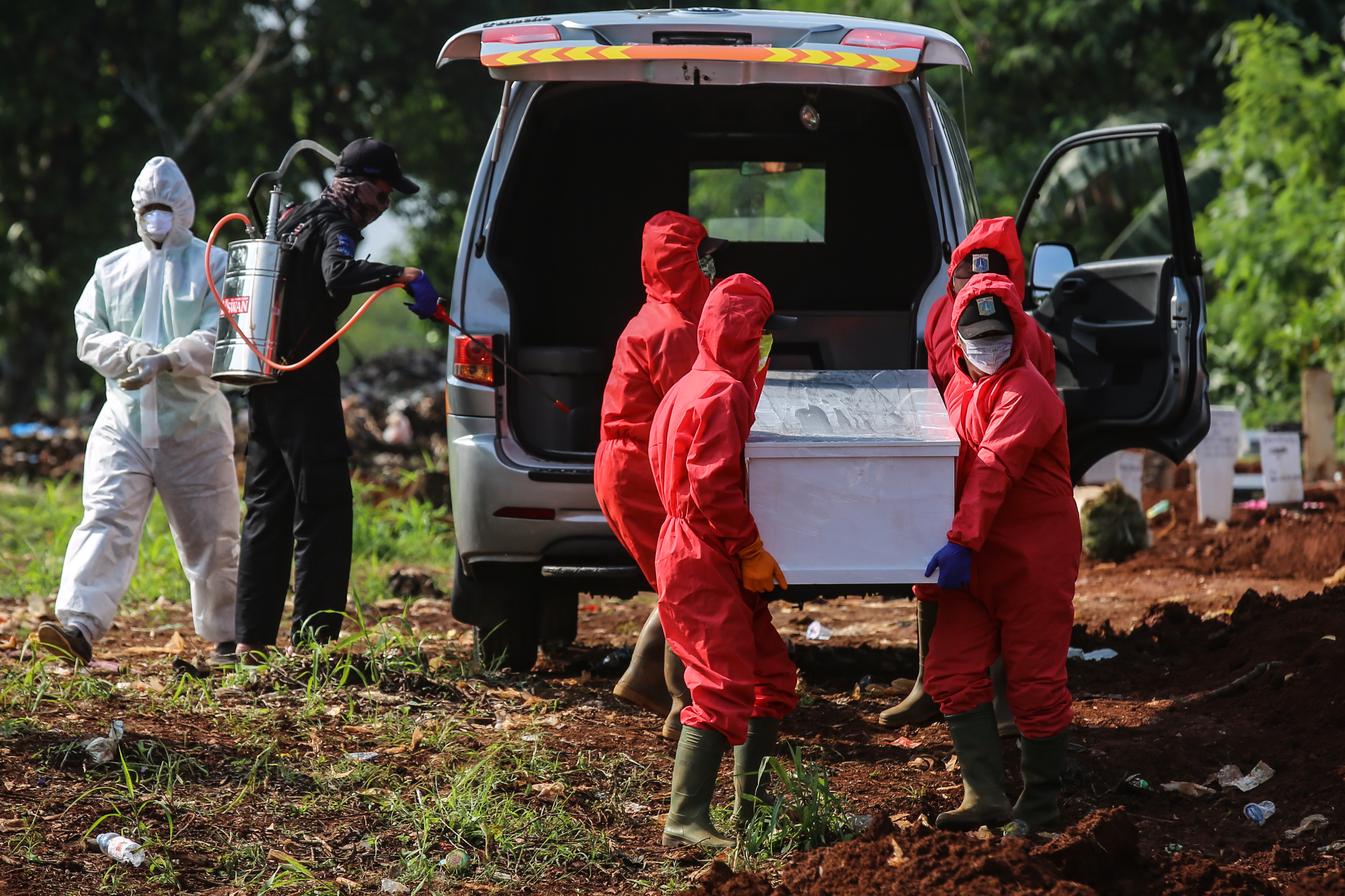 Petugas ber-APD siap memakamkan jenazah terjangkit covid-19 di Pondok Ranggon (7/5/2020)