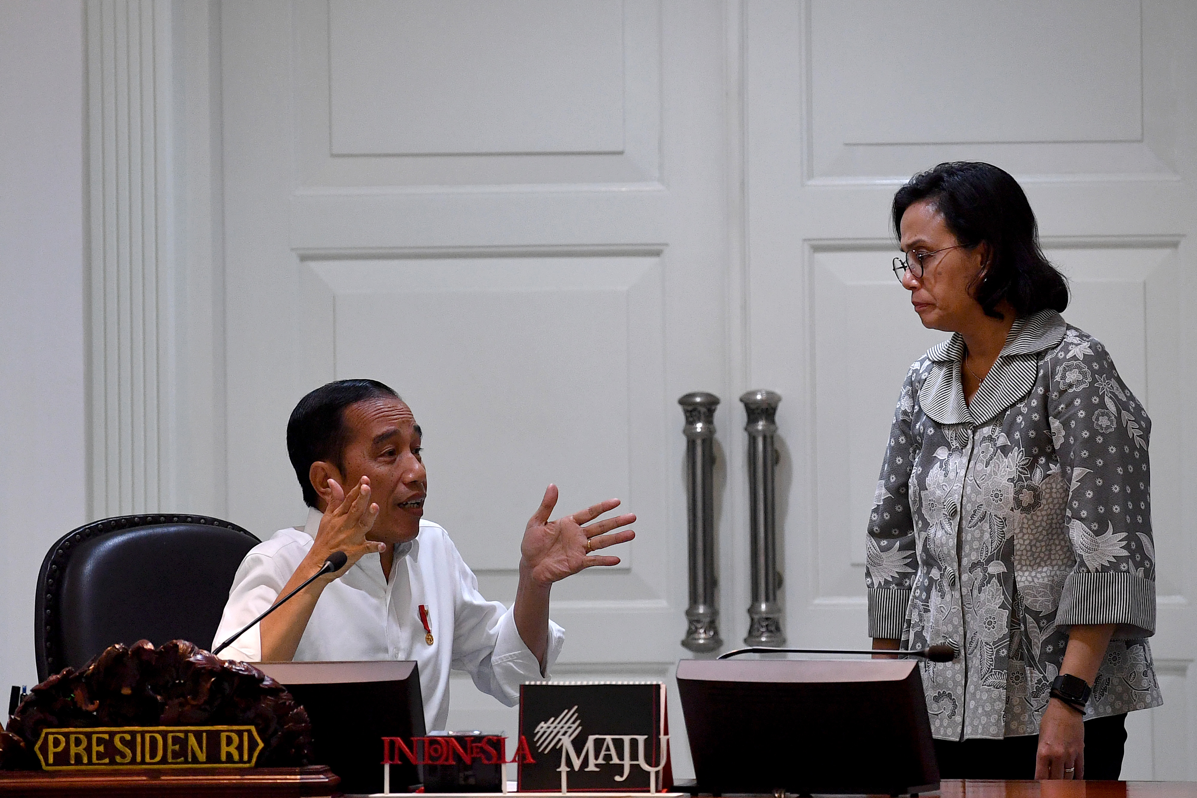 Presiden Joko Widodo berbincang dengan Menteri Keuangan Sri Mulyani di Istana Negara. ​​​​​​​