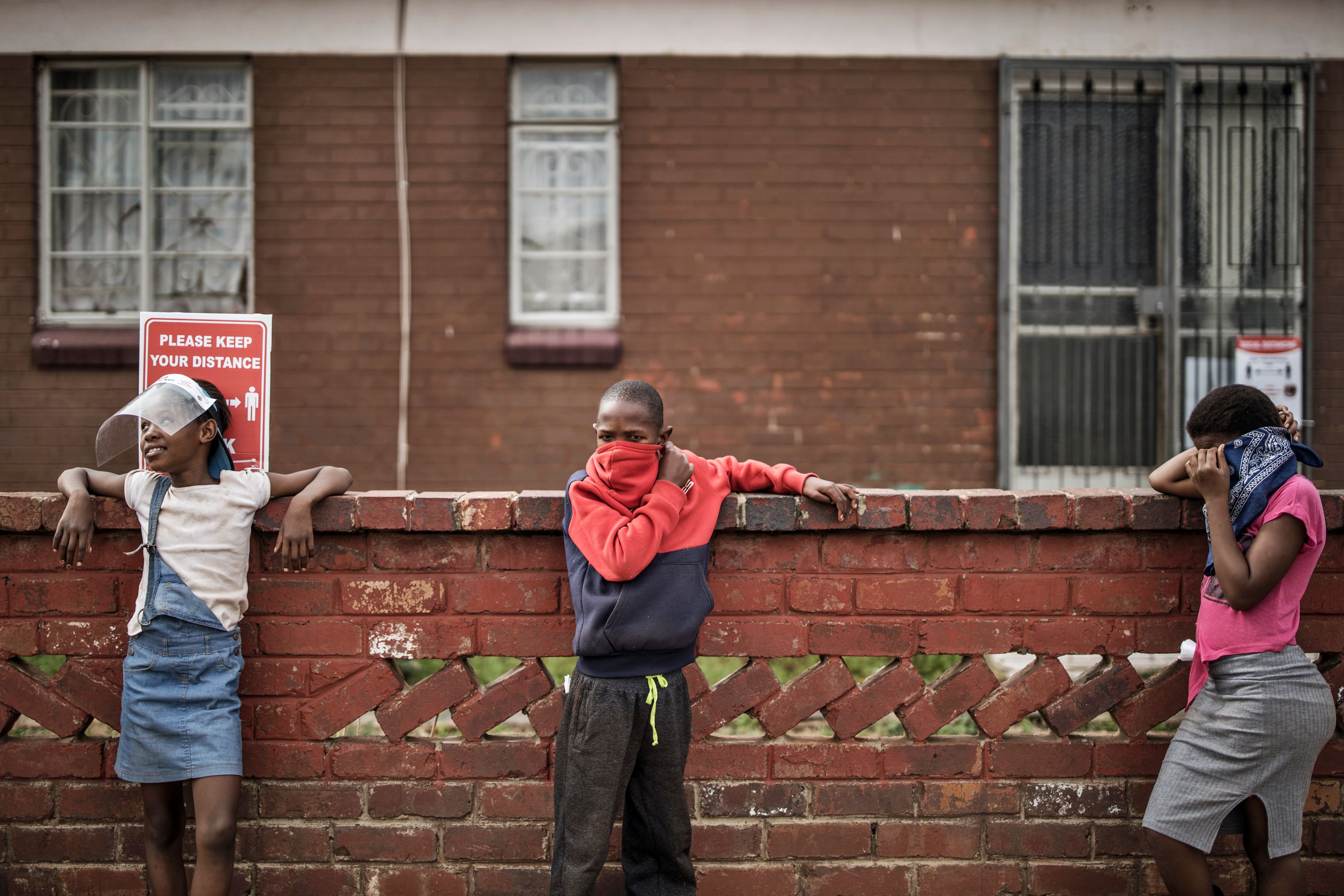 Anak-anak menjaga jarak saat mengantri makanan di Johannesburg, Afrika Selatan.