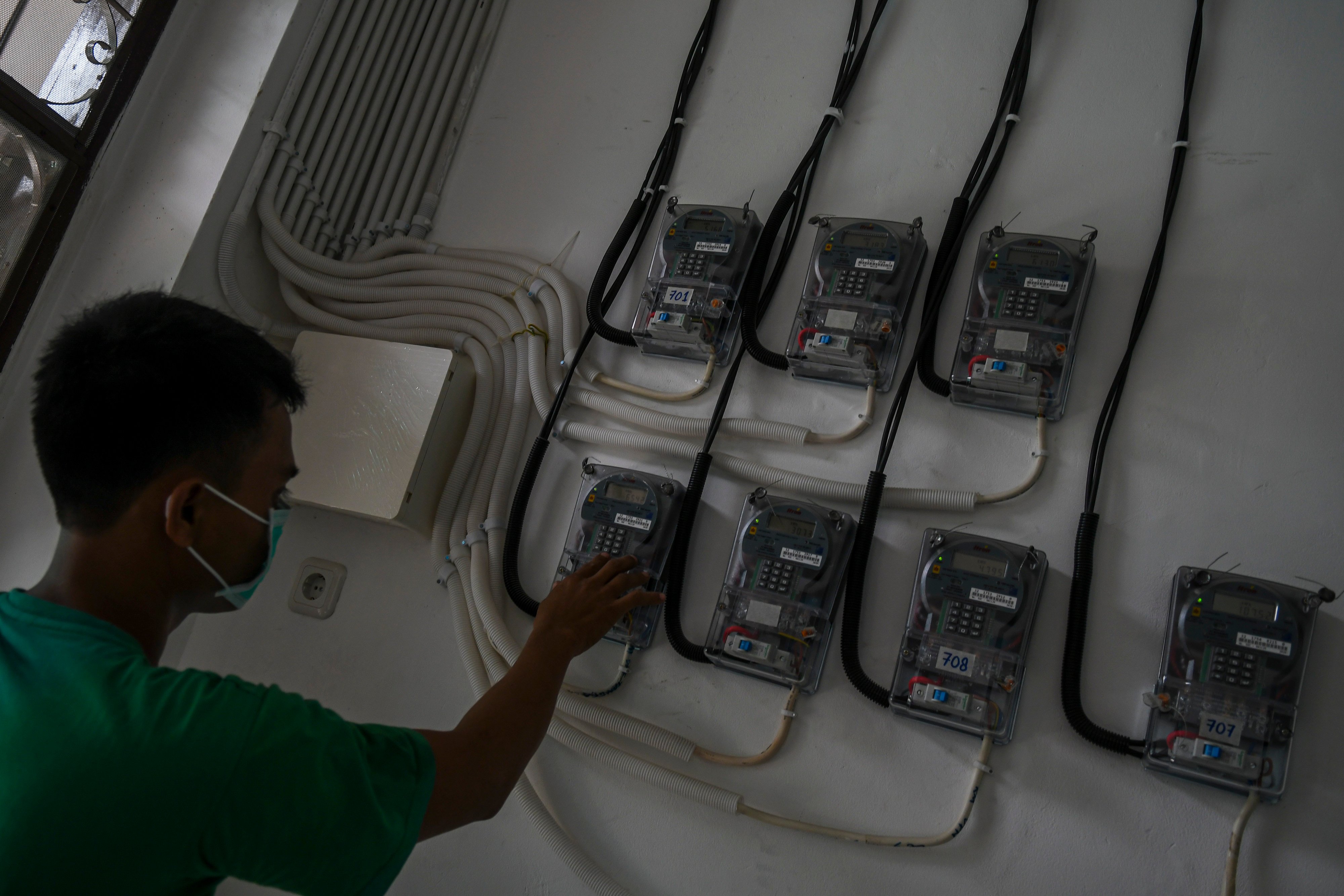 Pelanggan memasukkan pulsa listrik melalui meteran dengan sistem token.