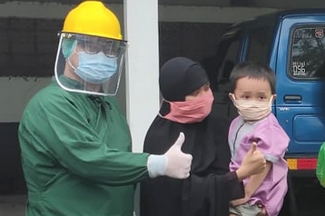Seorang anak berfoto bersama tenaga medis setelah dinyatakan sembuh dari covid-19 di RSUD Purbalingga, Jawa Tengah.