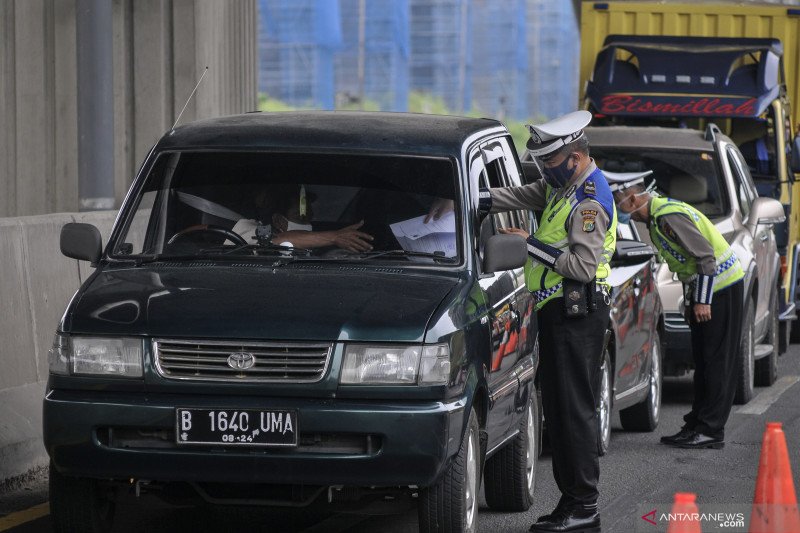 Petugas Kepolisian mengecek identitas mobil pribadi yang melintasi tol Jakarta-Cikampek di Cikarang Barat, Kabupaten Bekasi, Jawa Barat.