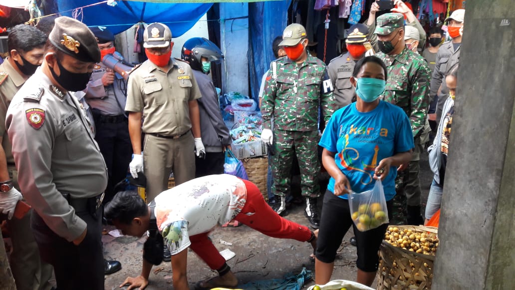 Salah seorang pengunjung Pasar Tradisional Siborong borong  dihukum push up karena tidak bermasker. 