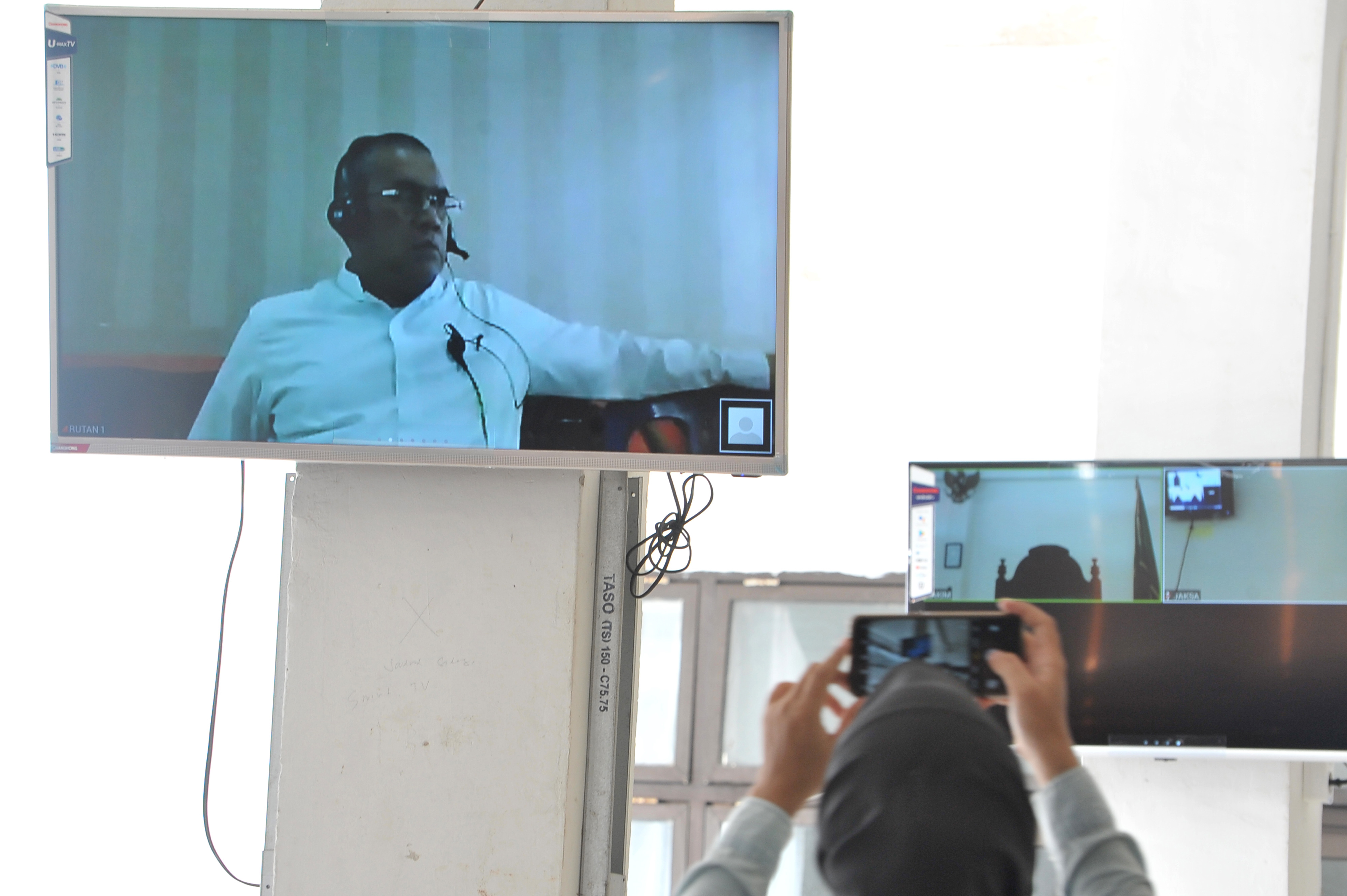 Jurnalis mengabadikan sidang Tindak Pidana Korupsi dengan Terdakwa Bupati Muara Enim Ahmad Yani yang berlangsung secara daring.