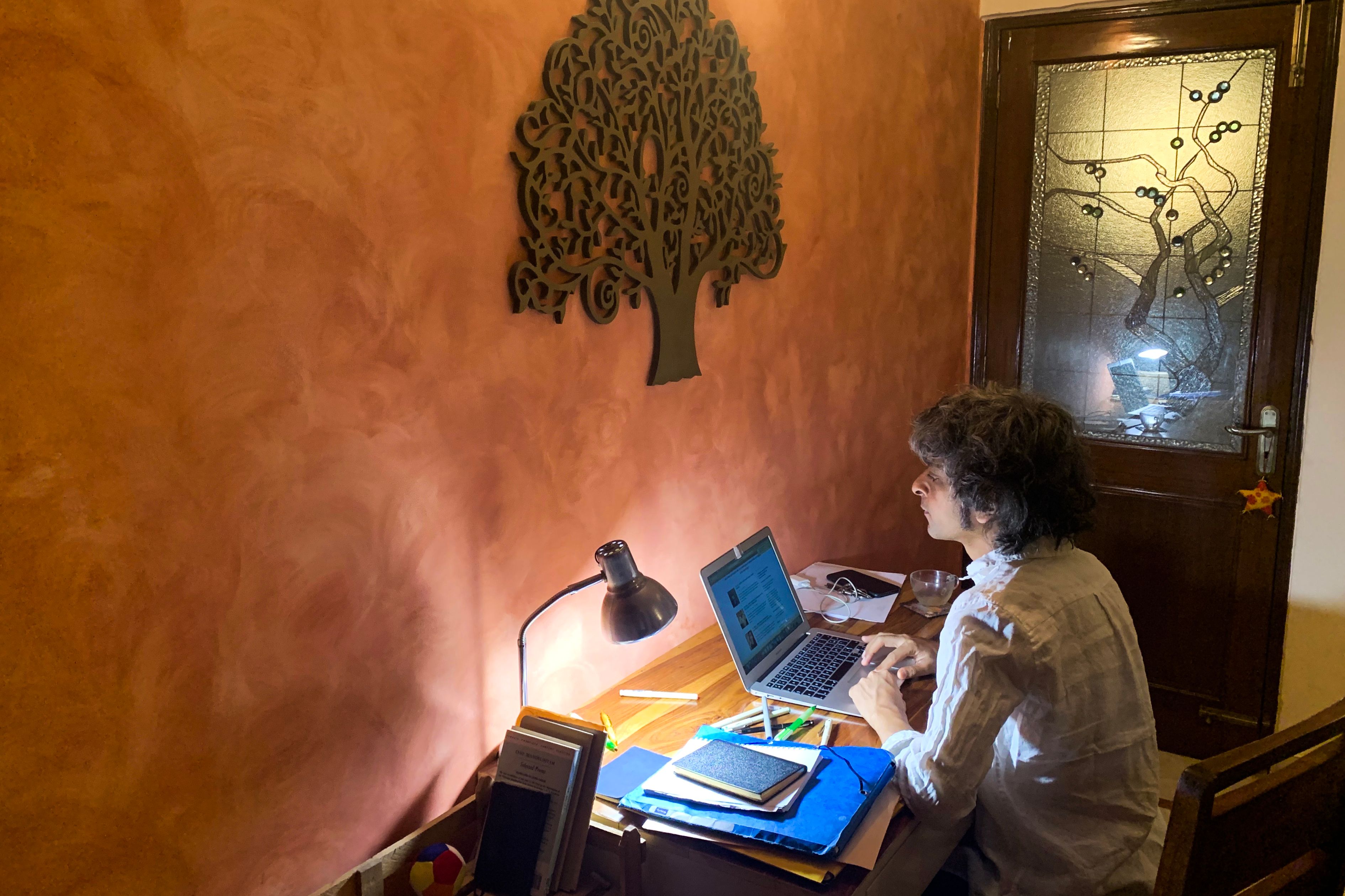 Seseorang tengah bekerja dengan laptopnya dari rumah di New Delhi, India.