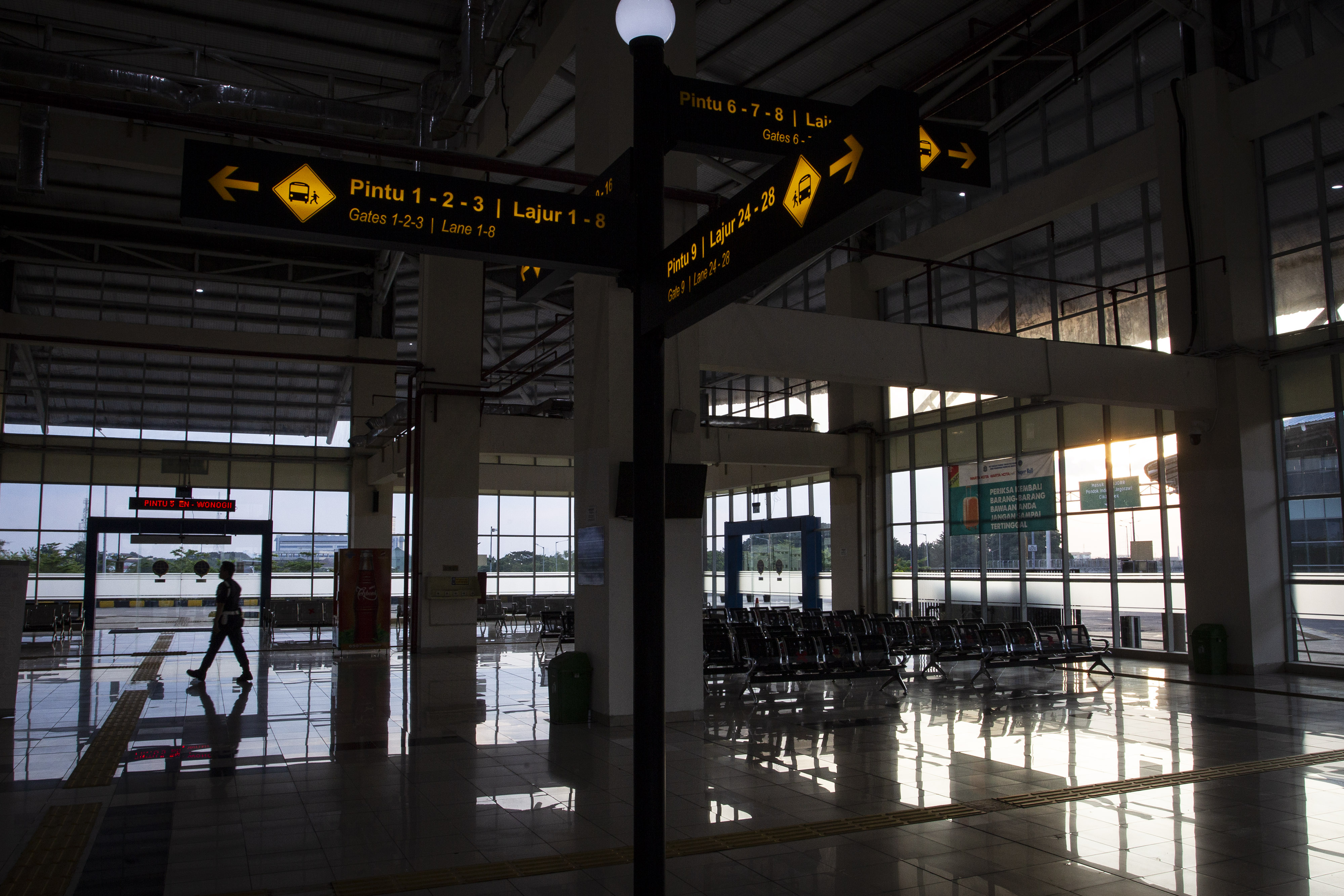 Petugas berjalan di ruang tunggu keberangkatan bus Antar Kota Antar Provinsi (AKAP) di Terminal Terpadu Pulo Gebang, Jakarta Timur