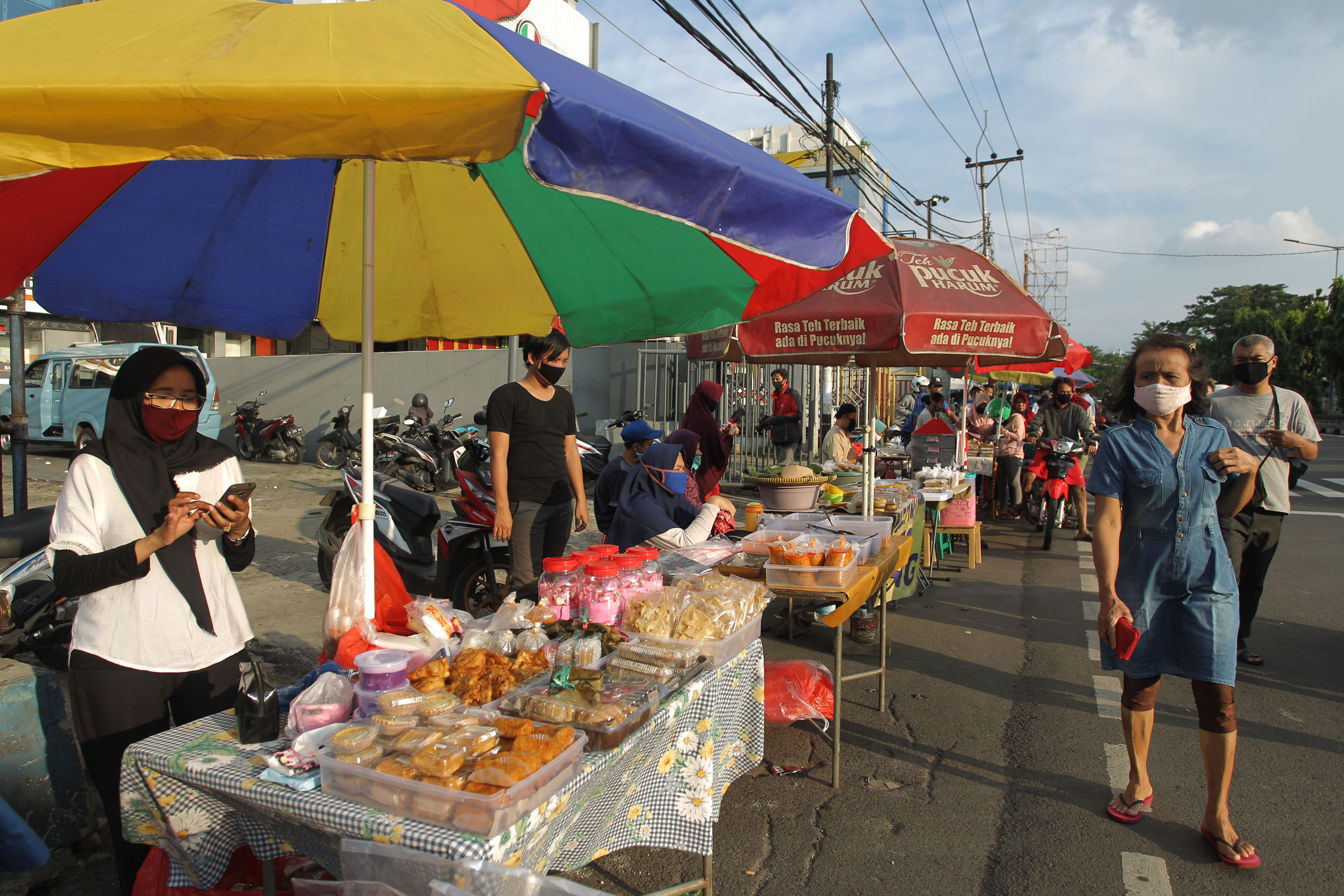 Pedagang melayani pembeli takjil di kawasan Jalan Panjang, Kebon Jeruk, Jakarta barat, Minggu (3/5). 